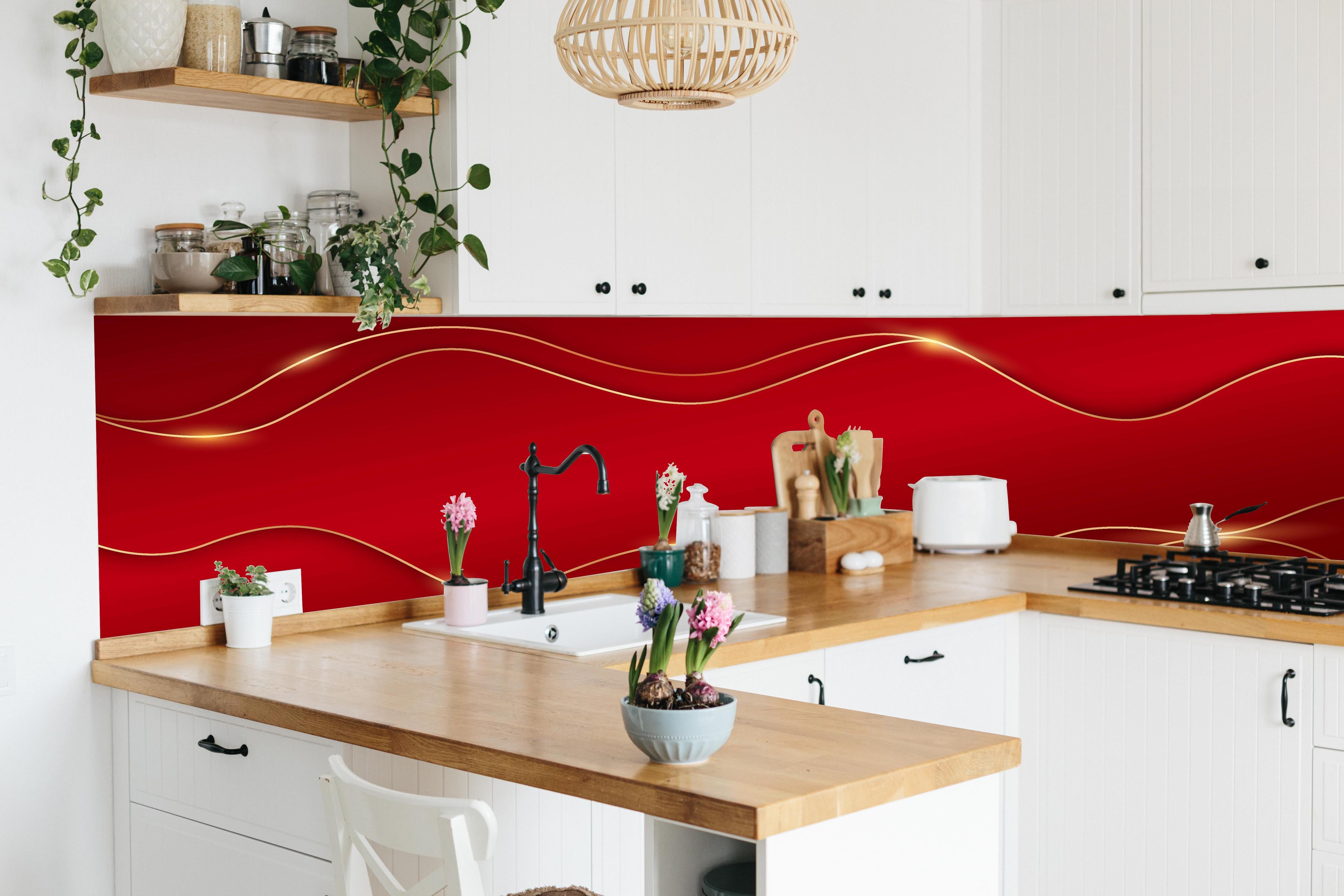 Küche - Elegantes Rot mit luxuriösen Goldlinien hinter weißen Hochglanz-Küchenregalen und schwarzem Wasserhahn