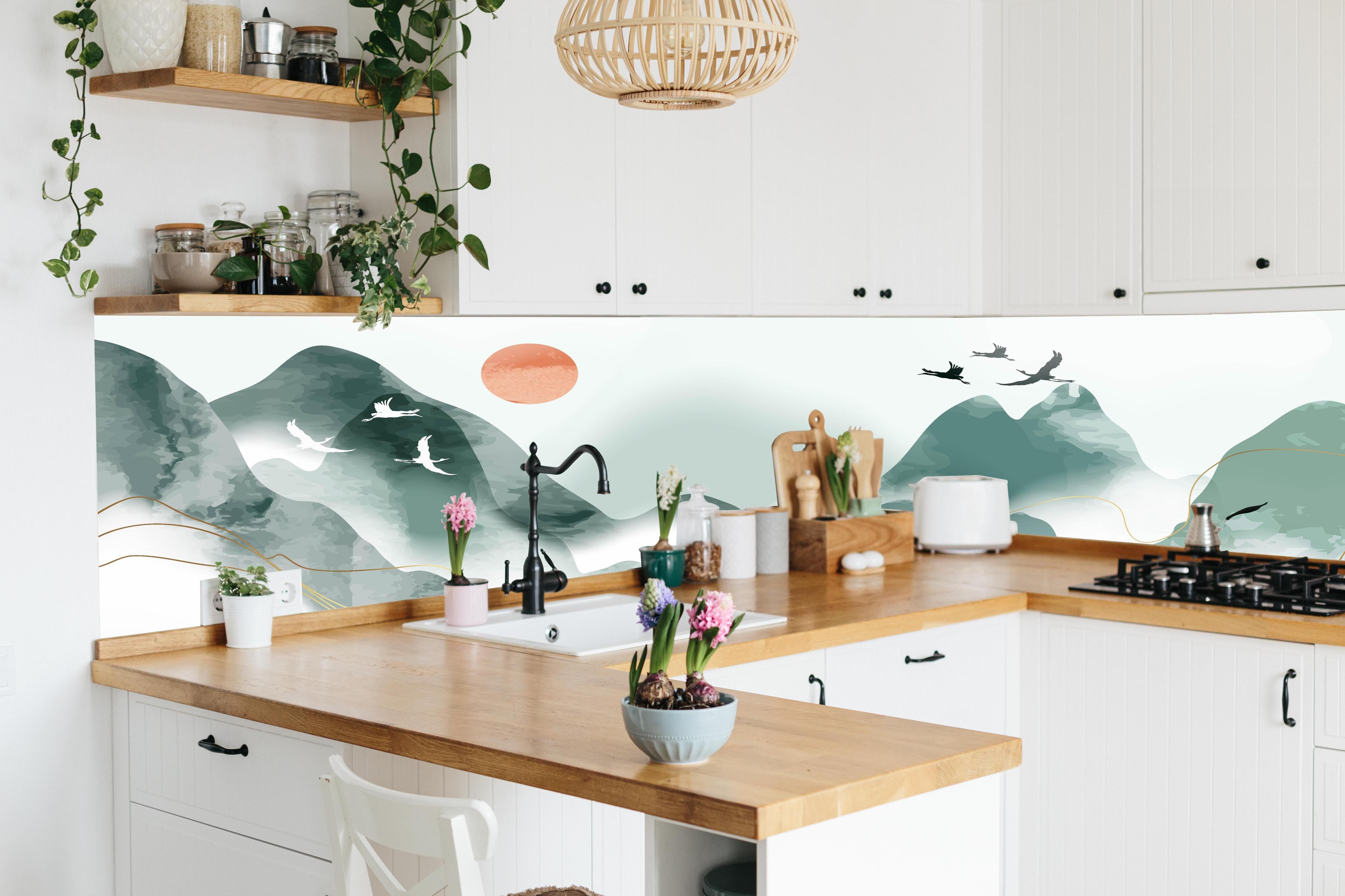 Küche - Entspannende Berglandschaft bei Sonnenuntergang hinter weißen Hochglanz-Küchenregalen und schwarzem Wasserhahn