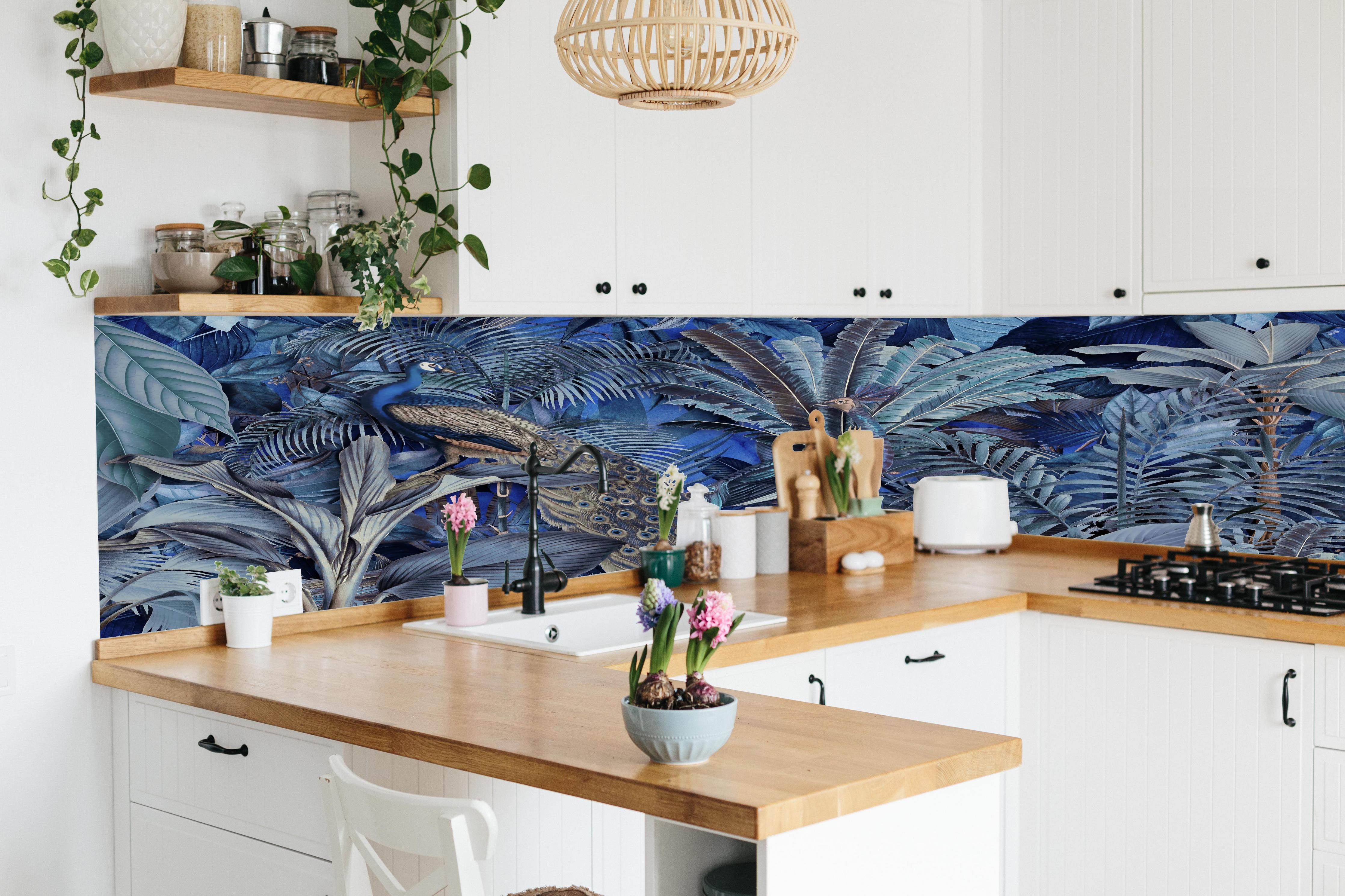 Küche - Exotischer Garten - Blaue Pfauen hinter weißen Hochglanz-Küchenregalen und schwarzem Wasserhahn