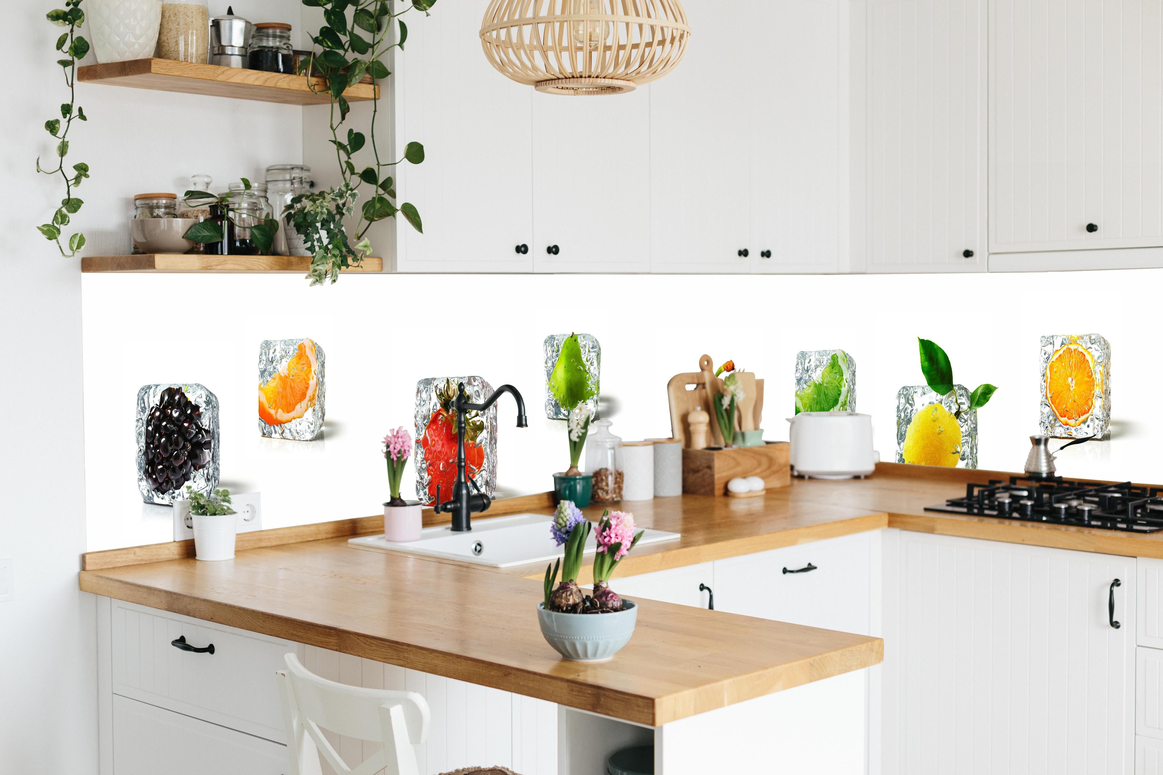 Küche - Farbenfrohes Obst-Eiswürfel Dekor hinter weißen Hochglanz-Küchenregalen und schwarzem Wasserhahn