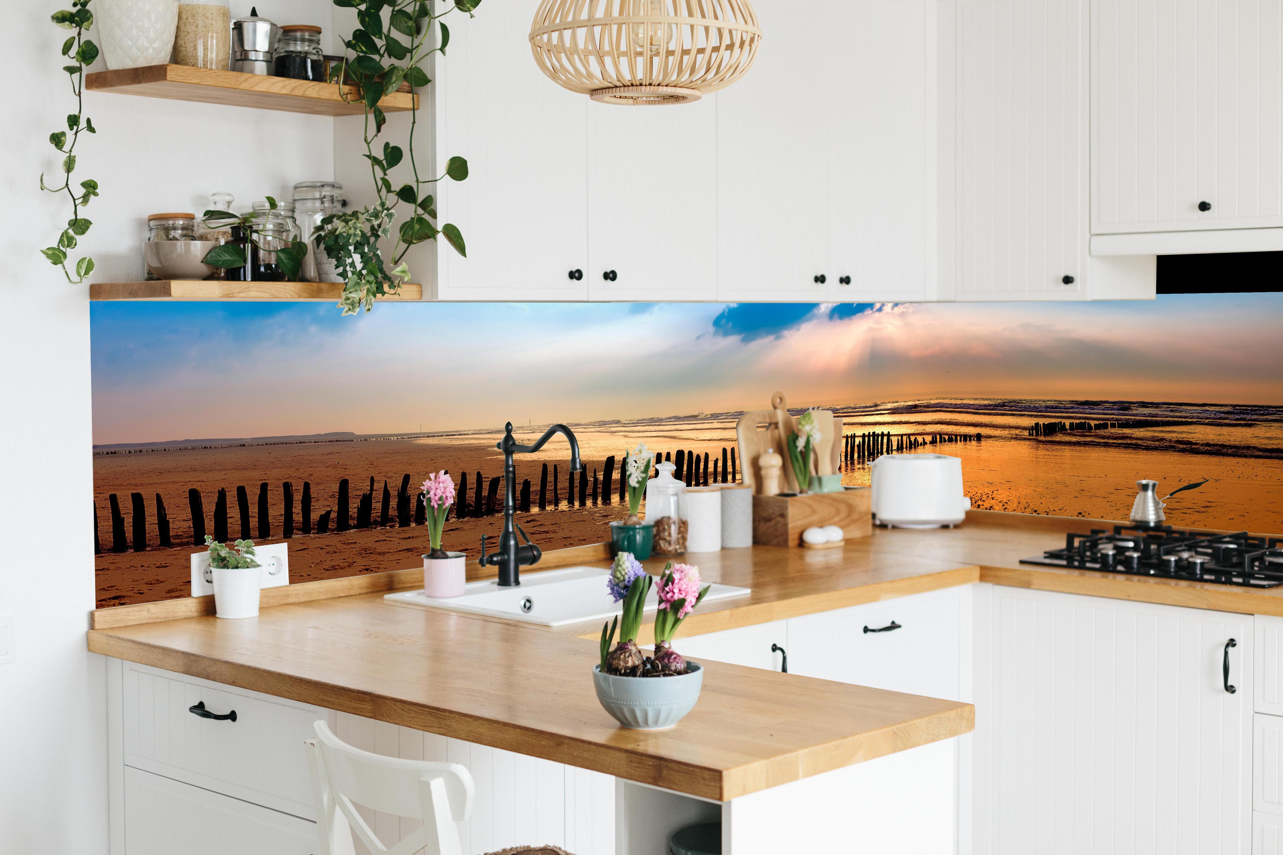 Küche - Faszinierender Sonnenuntergang über dem ruhigen Meer hinter weißen Hochglanz-Küchenregalen und schwarzem Wasserhahn