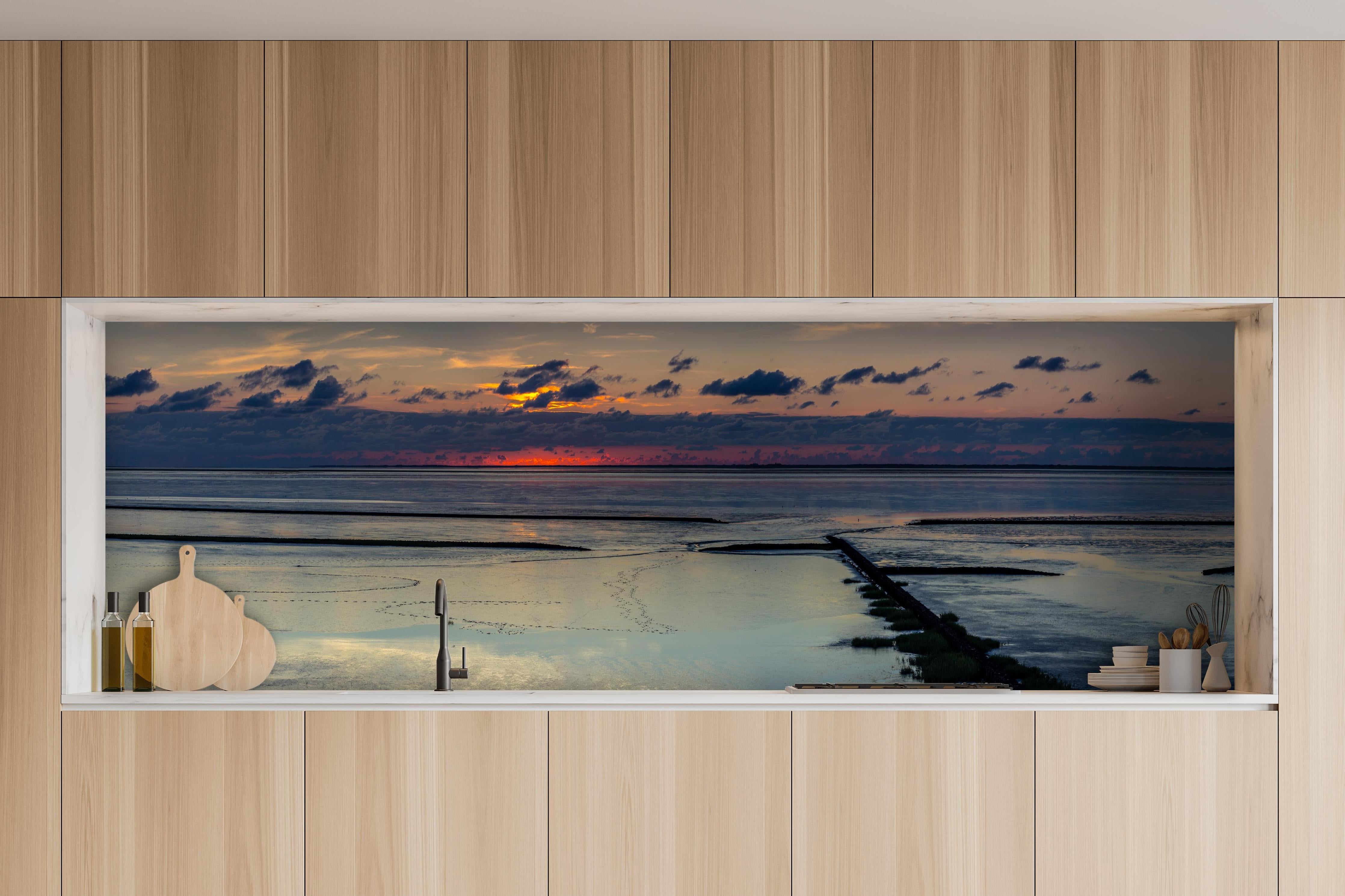 Küche - Faszinierender Sonnenuntergang über einem stillen Gewässer hinter weißen Hochglanz-Küchenregalen und schwarzem Wasserhahn