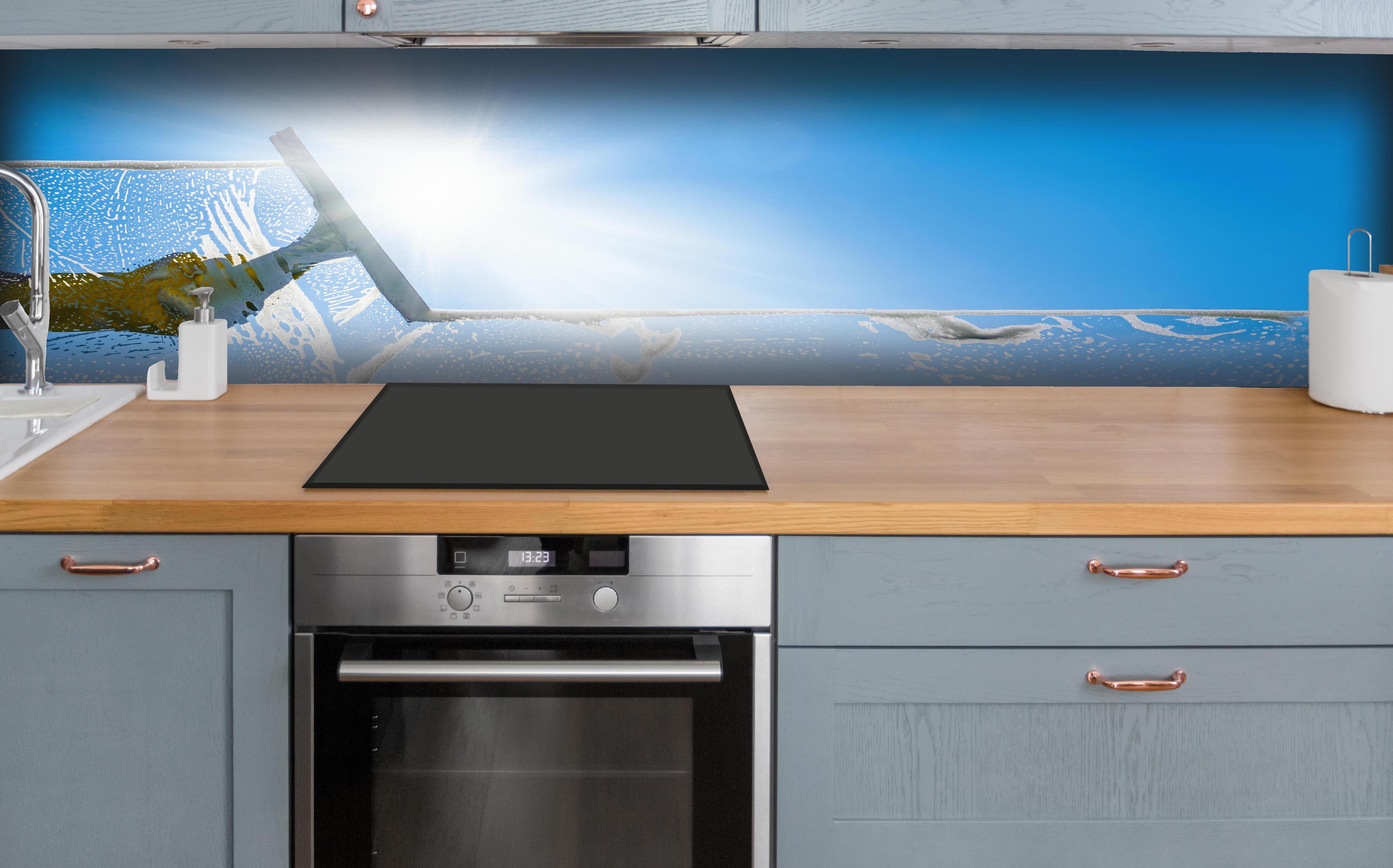 Küche - Fensterputzer mit Abzieher und strahlendem Himmel hinter weißen Hochglanz-Küchenregalen und schwarzem Wasserhahn