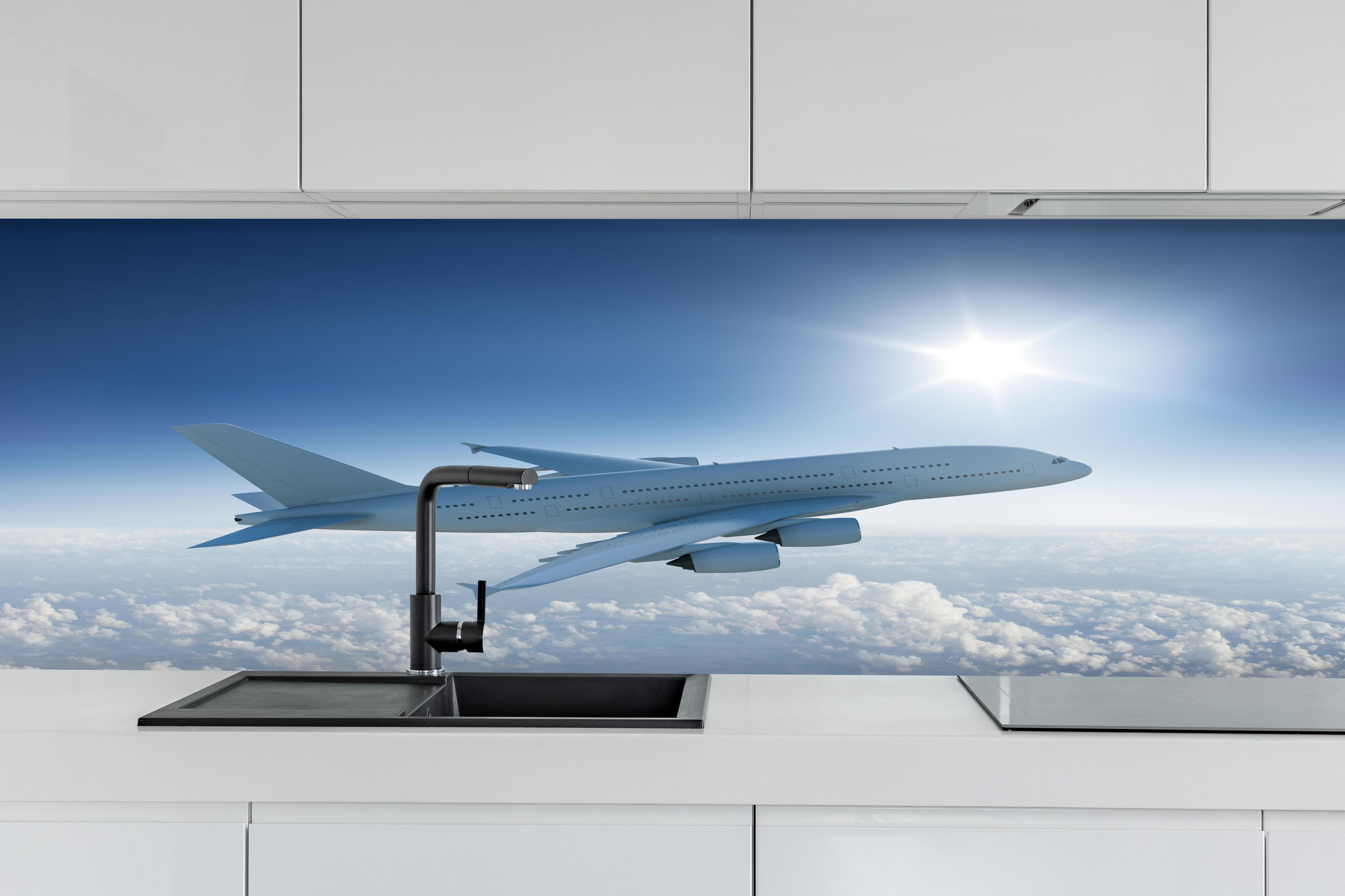 Küche - Flugzeug über weißen Wolken hinter weißen Hochglanz-Küchenregalen und schwarzem Wasserhahn