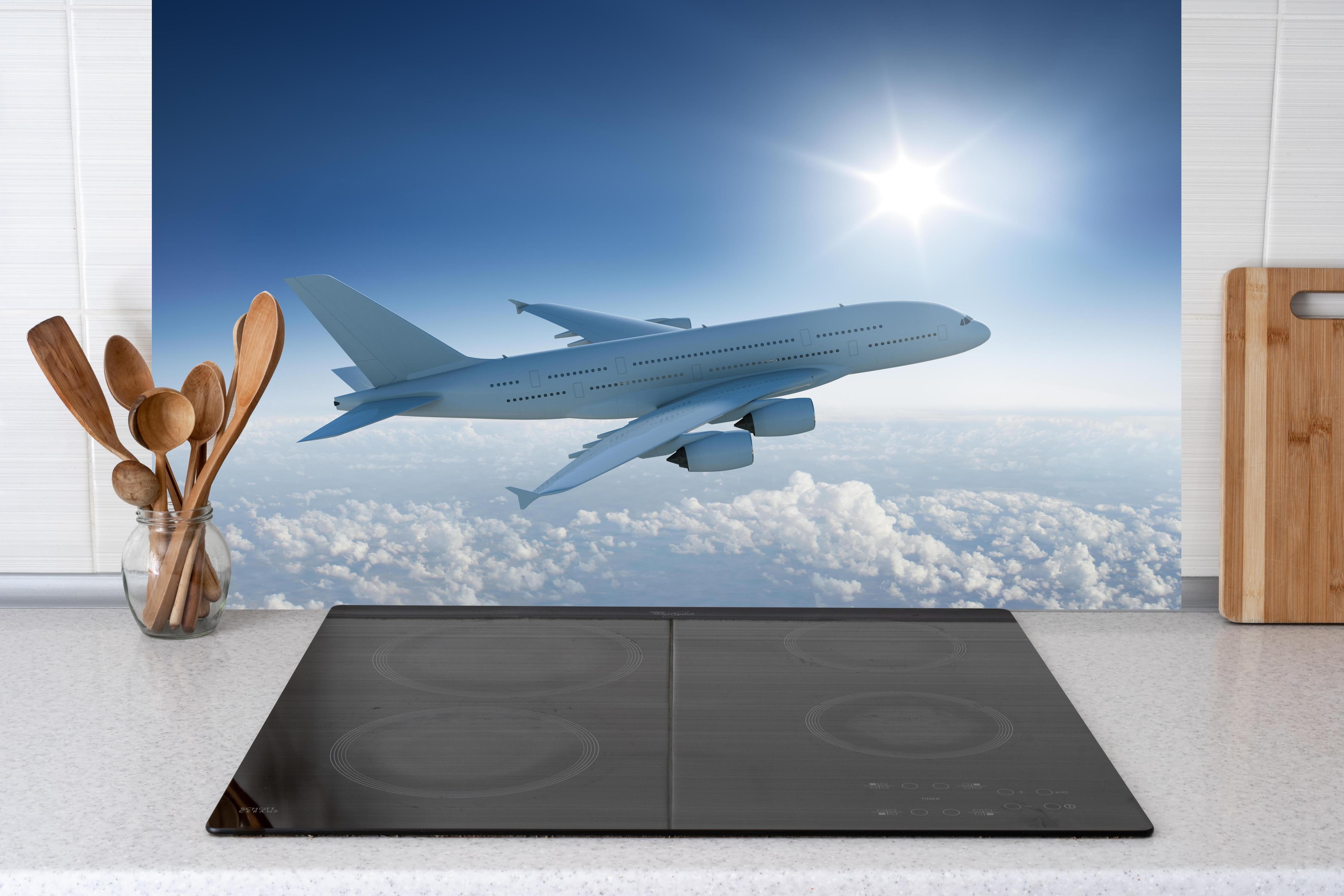 Küche - Flugzeug über weißen Wolken hinter weißen Hochglanz-Küchenregalen und schwarzem Wasserhahn