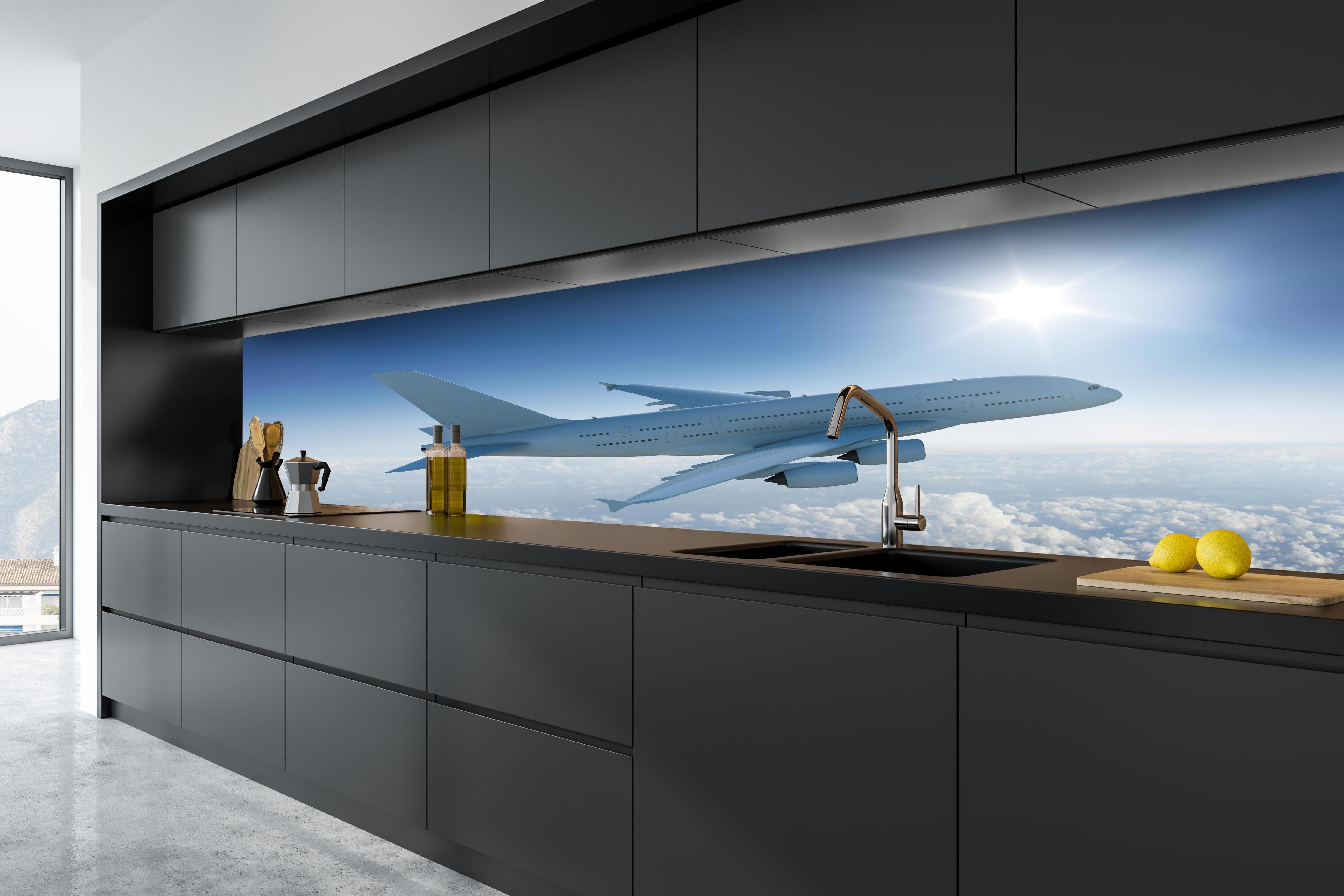Küche - Flugzeug über weißen Wolken hinter weißen Hochglanz-Küchenregalen und schwarzem Wasserhahn