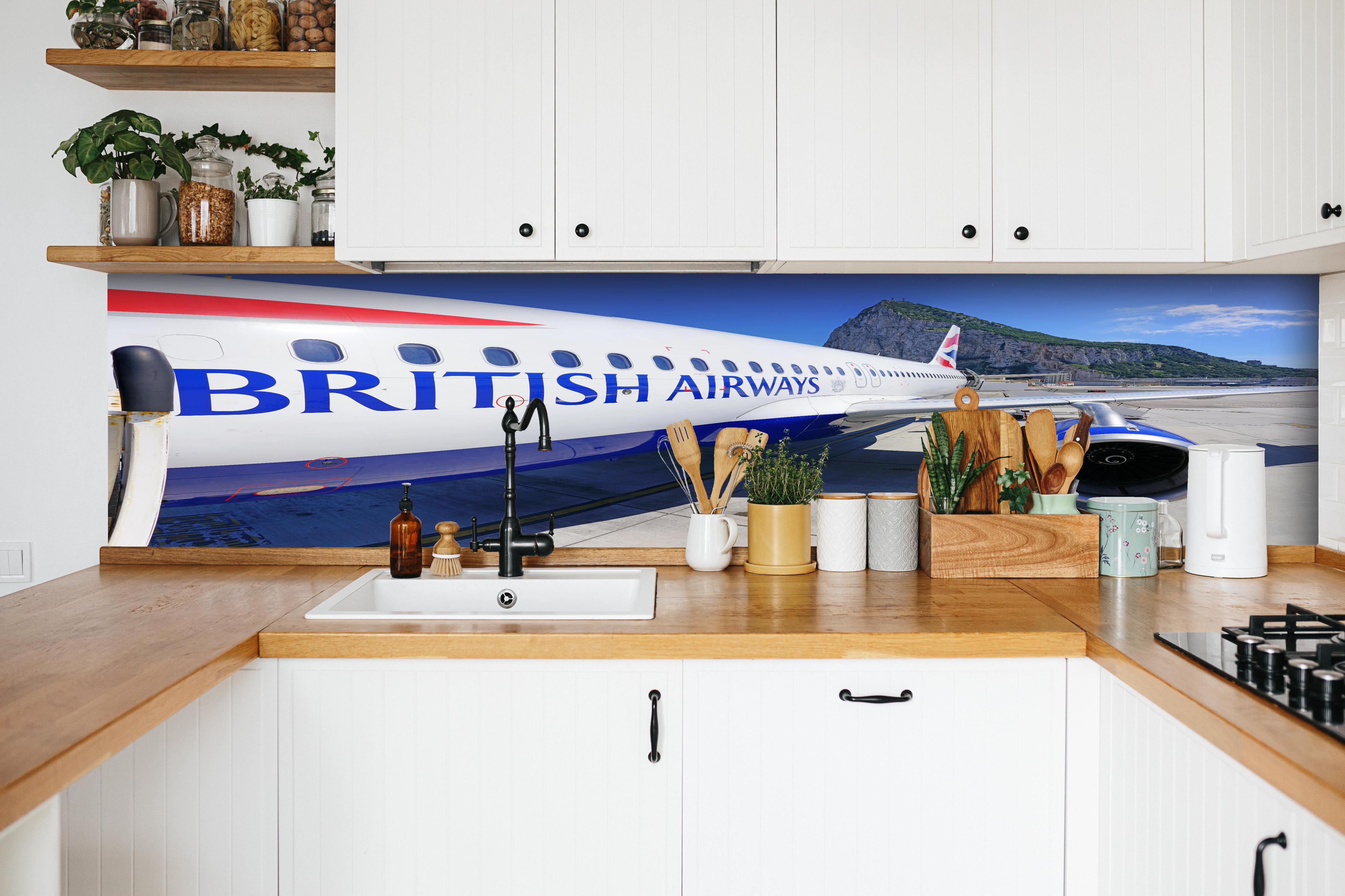 Küche - Flugzeug von British Airways hinter weißen Hochglanz-Küchenregalen und schwarzem Wasserhahn