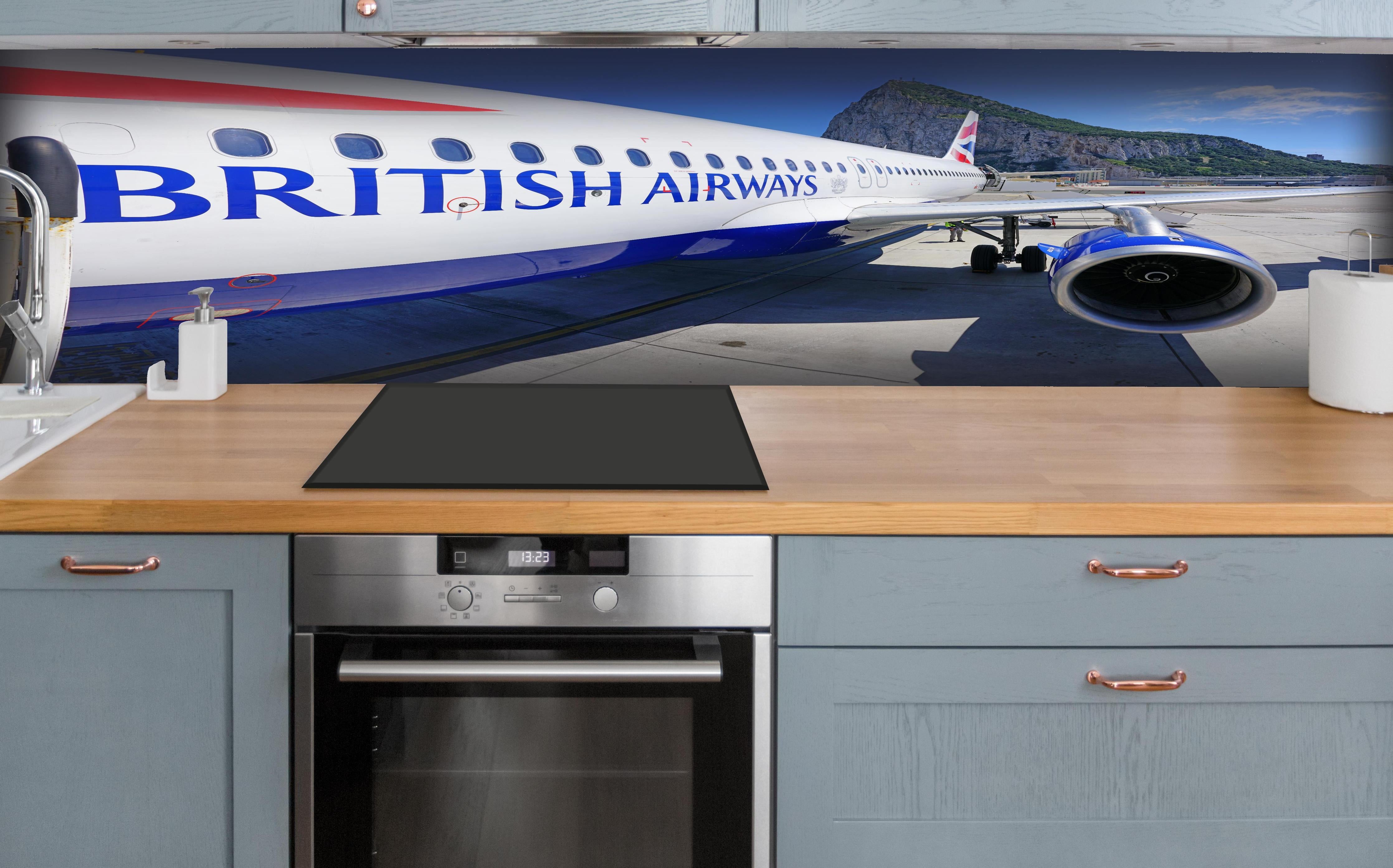 Küche - Flugzeug von British Airways hinter weißen Hochglanz-Küchenregalen und schwarzem Wasserhahn