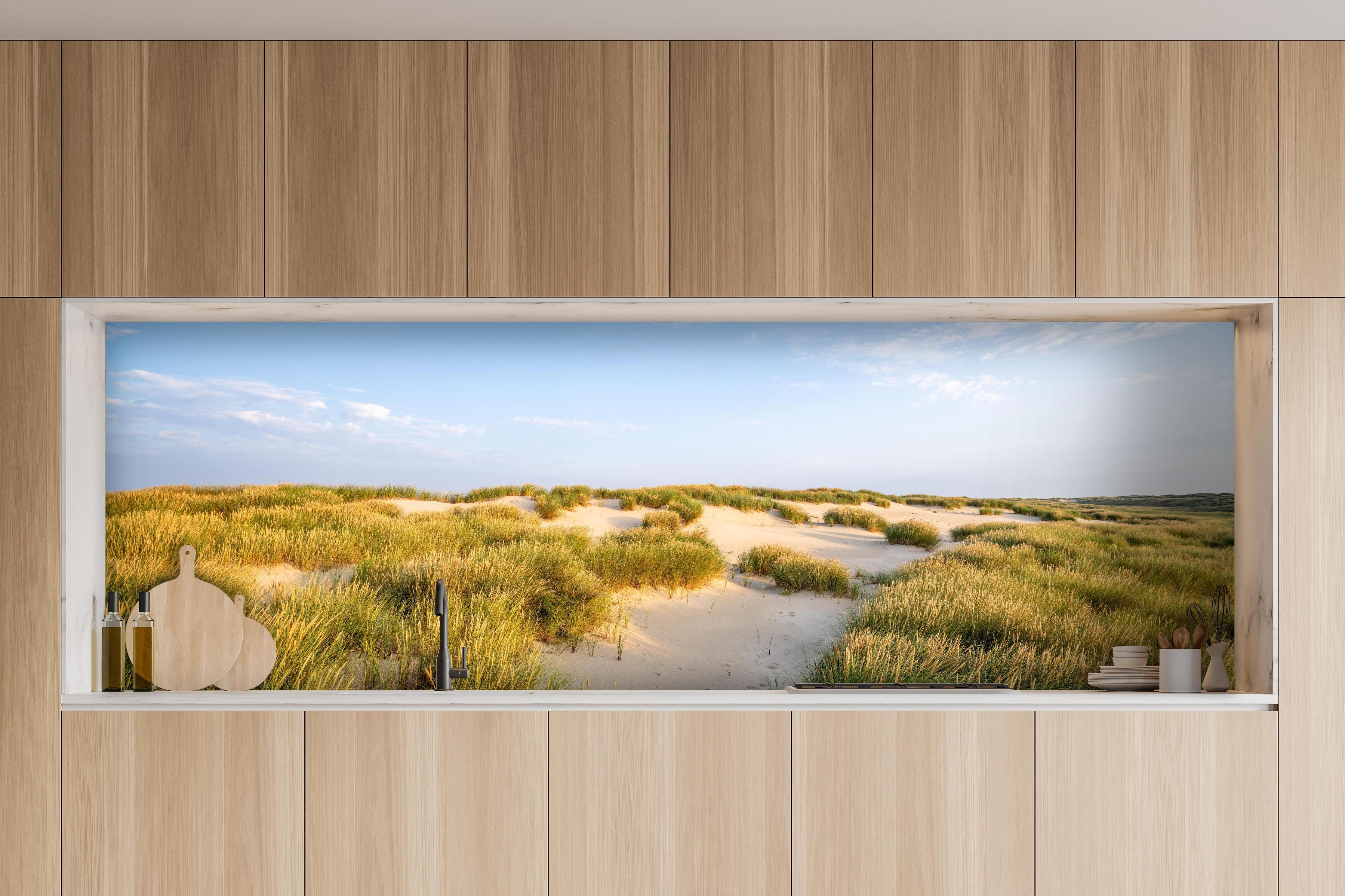 Küche - Friedliche Dünenlandschaft mit leuchtendem Gras im warmen Sonnenlicht hinter weißen Hochglanz-Küchenregalen und schwarzem Wasserhahn