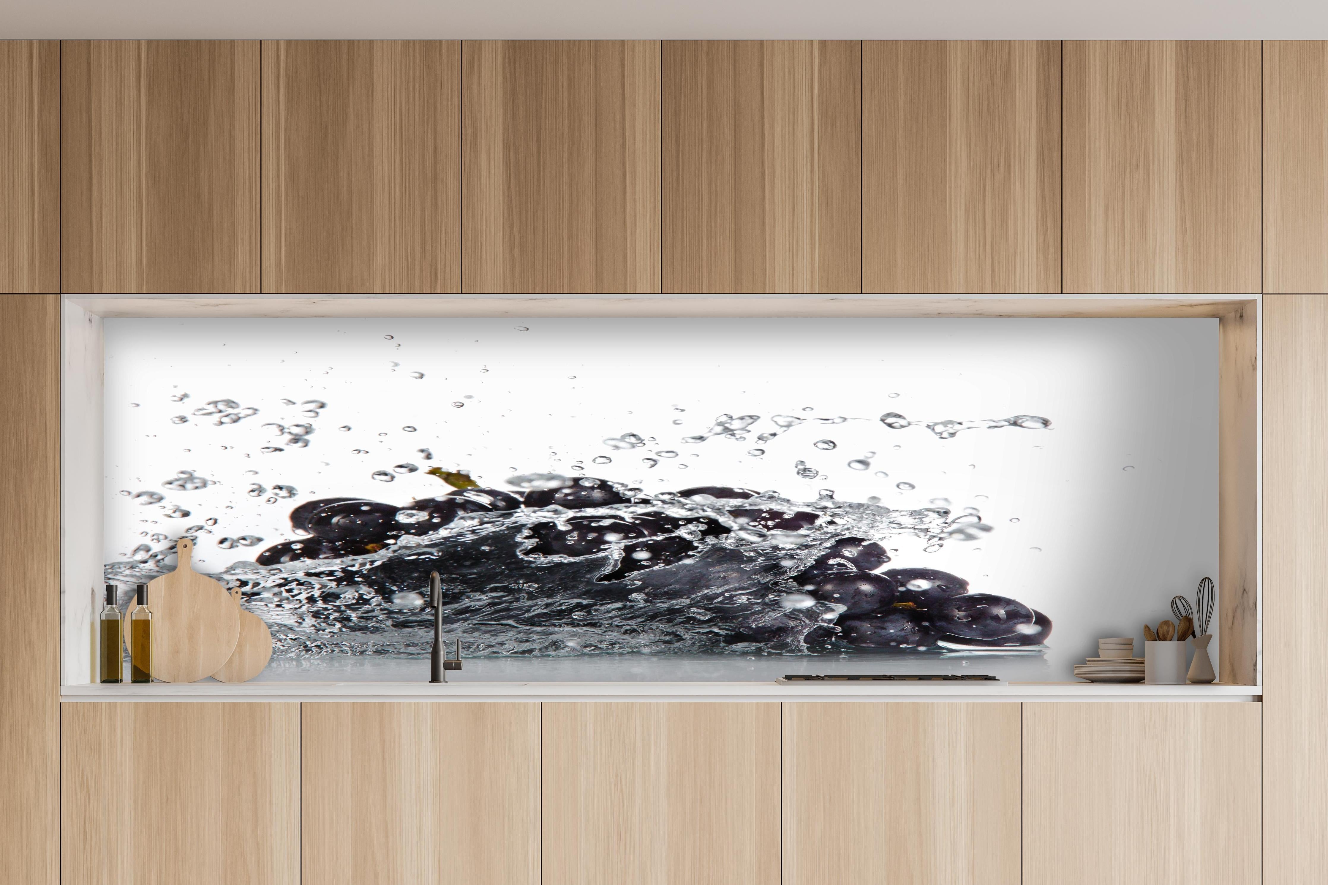 Küche - Frische Trauben im Wasser Splash hinter weißen Hochglanz-Küchenregalen und schwarzem Wasserhahn