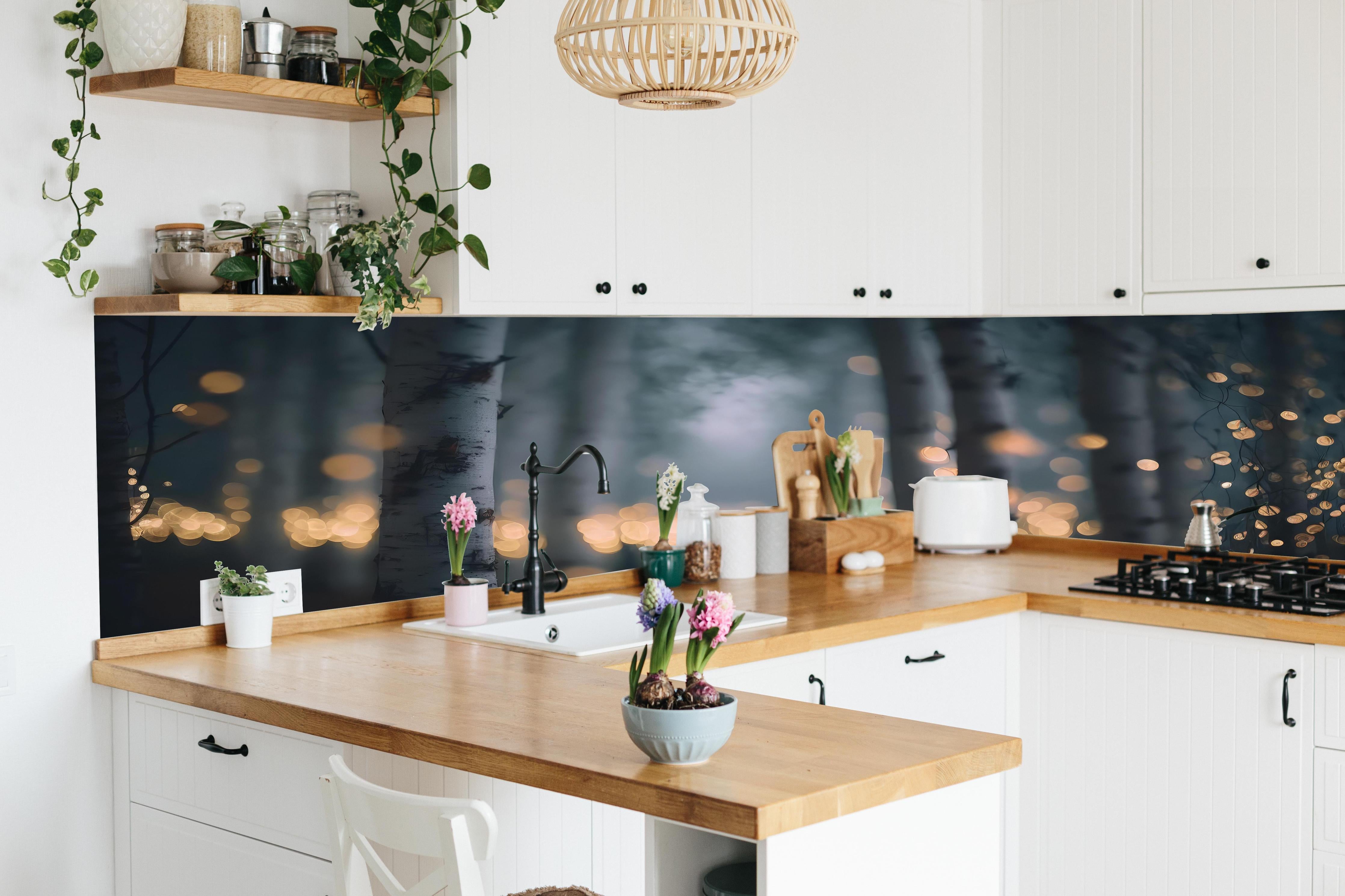 Küche - Funkelnder Birkenwald hinter weißen Hochglanz-Küchenregalen und schwarzem Wasserhahn