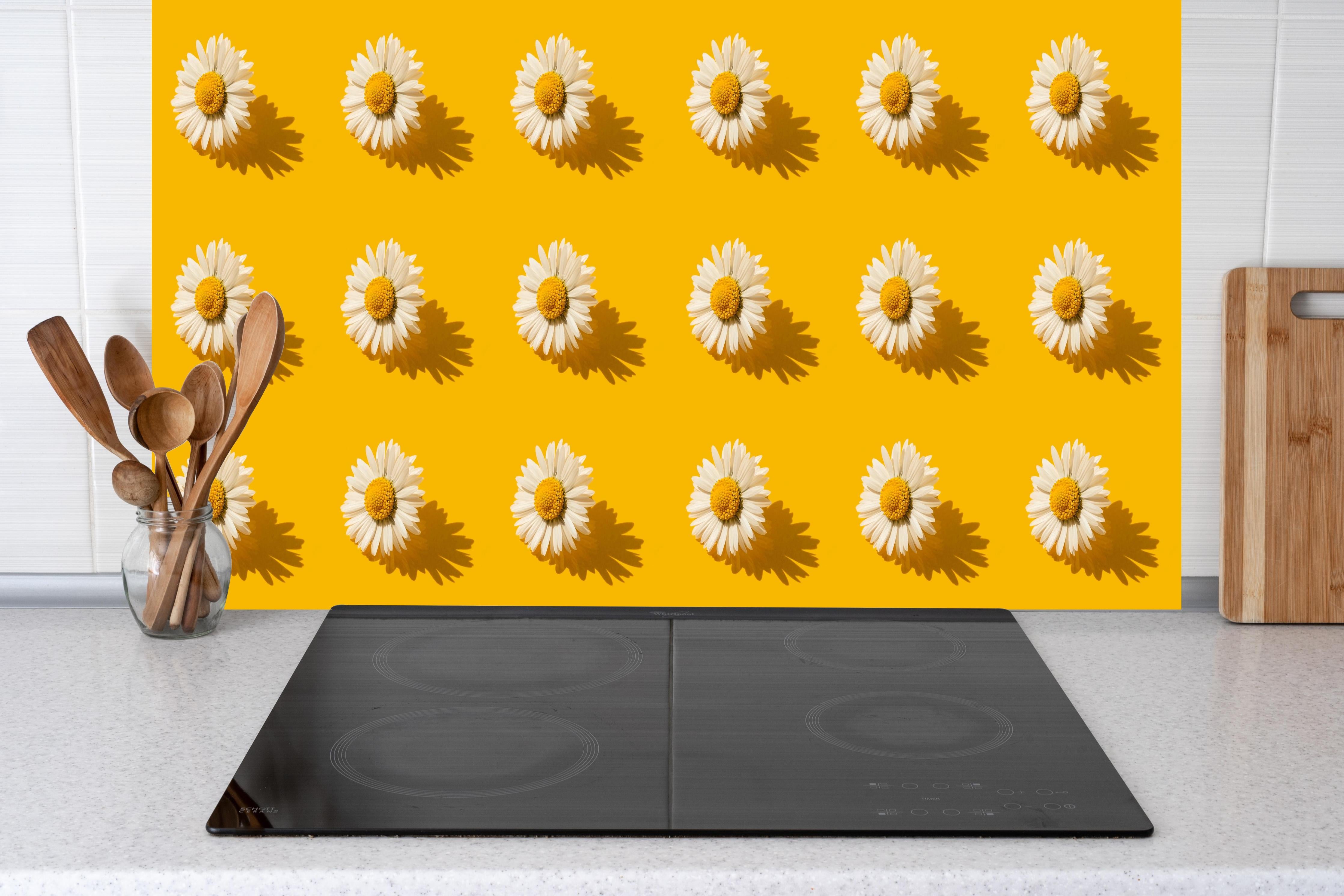 Küche - Gänseblümchen Muster auf gelbem Hintergrund hinter weißen Hochglanz-Küchenregalen und schwarzem Wasserhahn