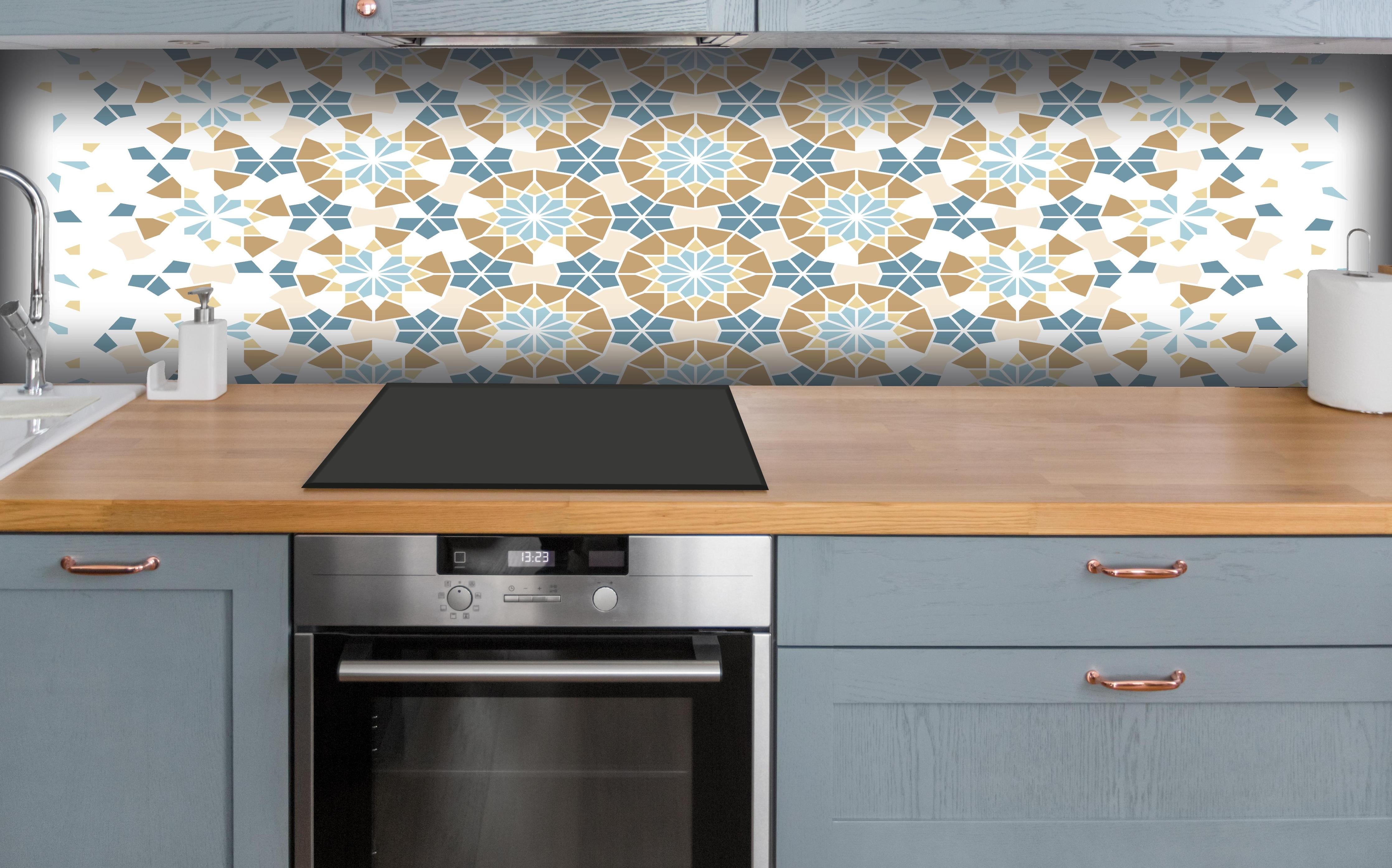 Küche - Geometrisches Muster in Blau und Beige hinter weißen Hochglanz-Küchenregalen und schwarzem Wasserhahn