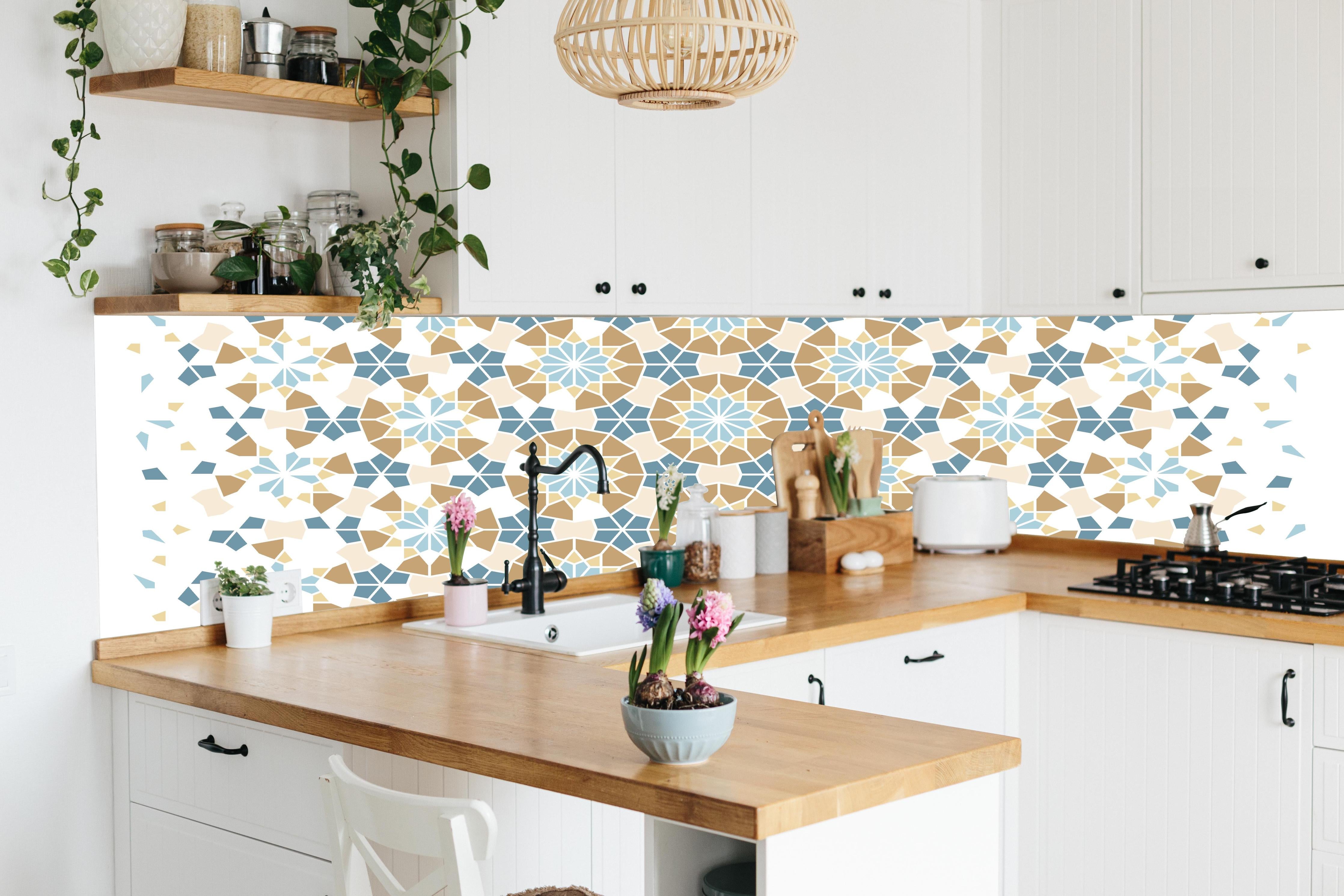 Küche - Geometrisches Muster in Blau und Beige hinter weißen Hochglanz-Küchenregalen und schwarzem Wasserhahn