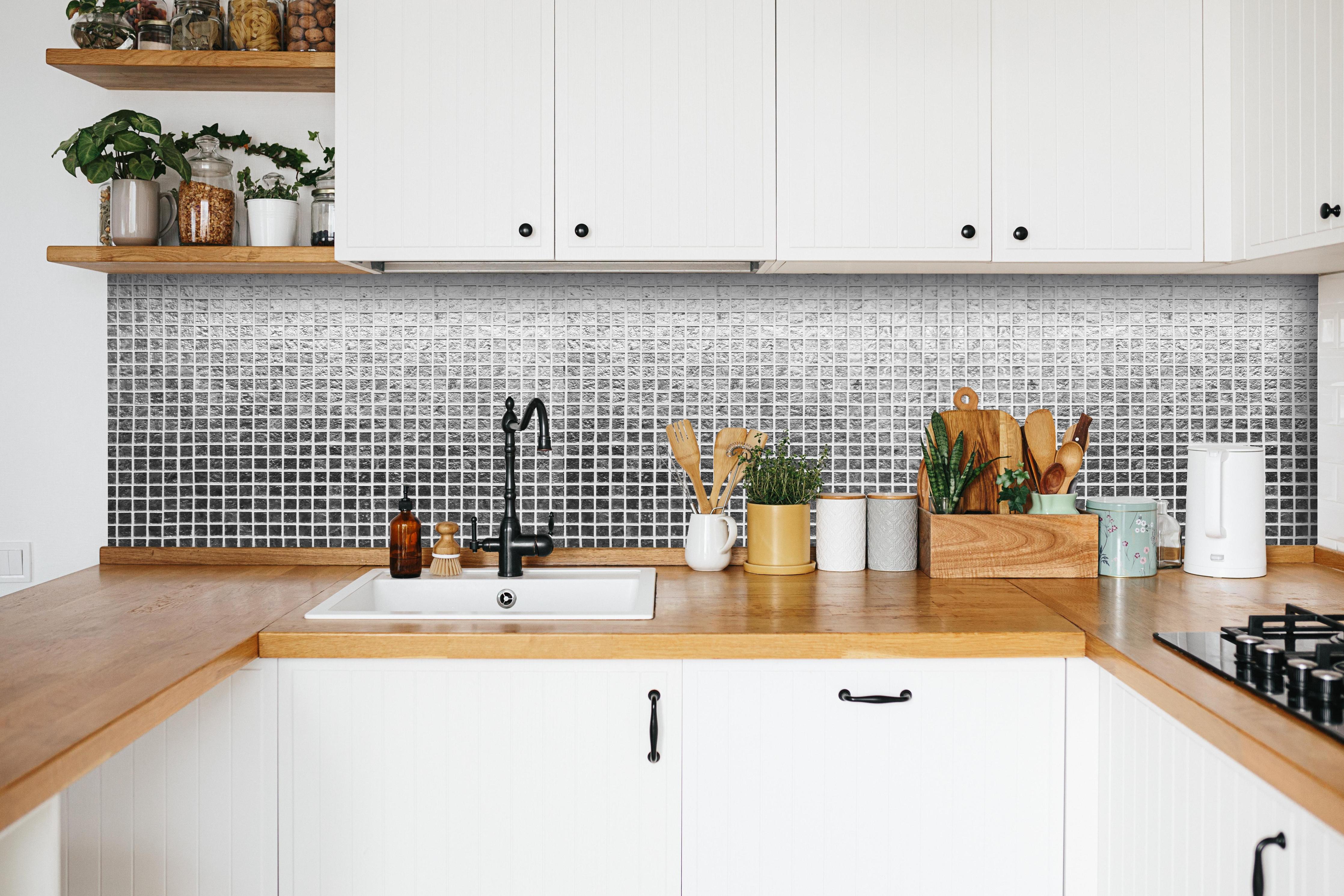 Küche - Glänzende Silberne Fliesen Textur Wand hinter weißen Hochglanz-Küchenregalen und schwarzem Wasserhahn