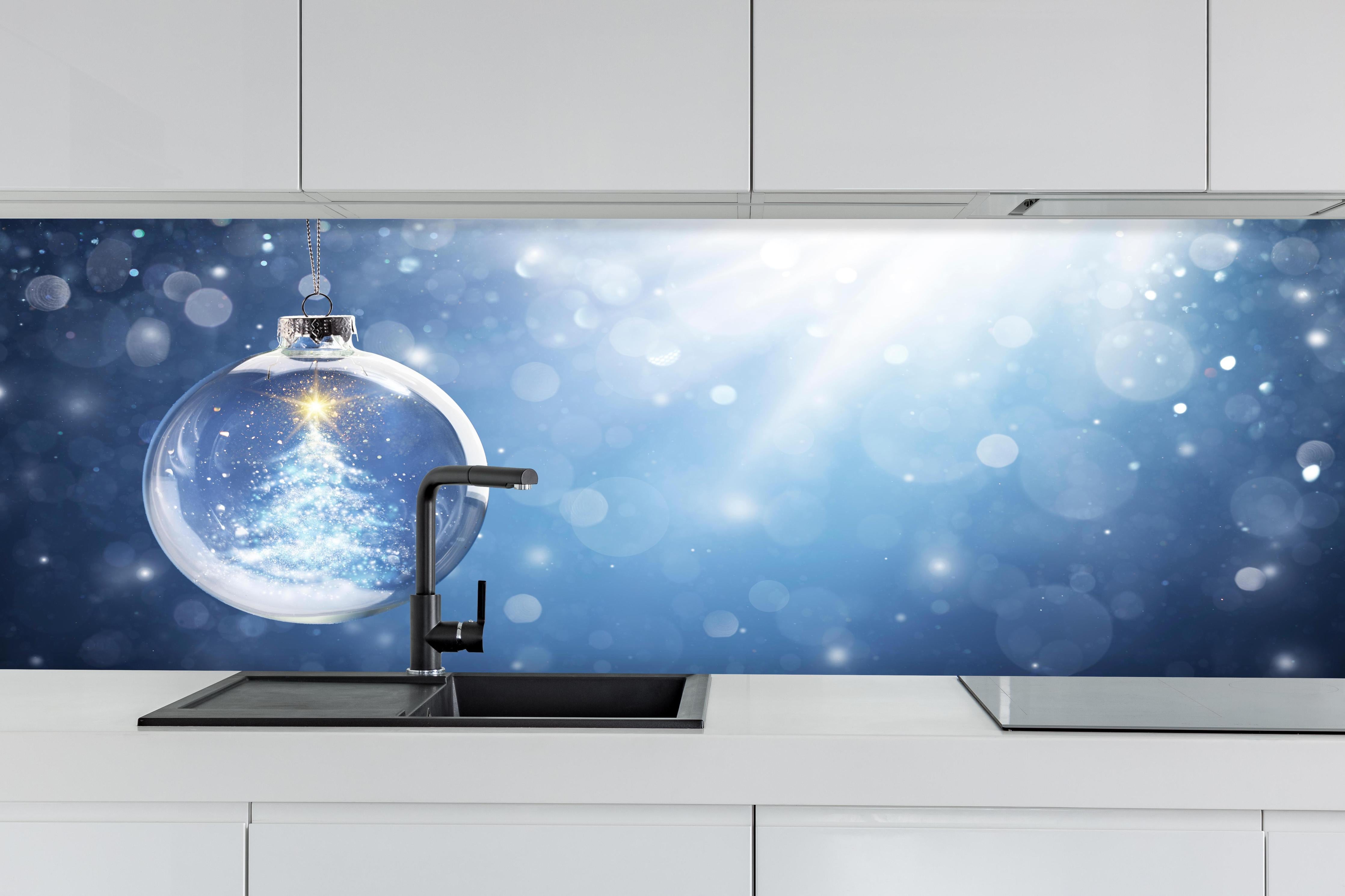 Küche - Glänzender Weihnachtsbaum in Schneekugel hinter weißen Hochglanz-Küchenregalen und schwarzem Wasserhahn