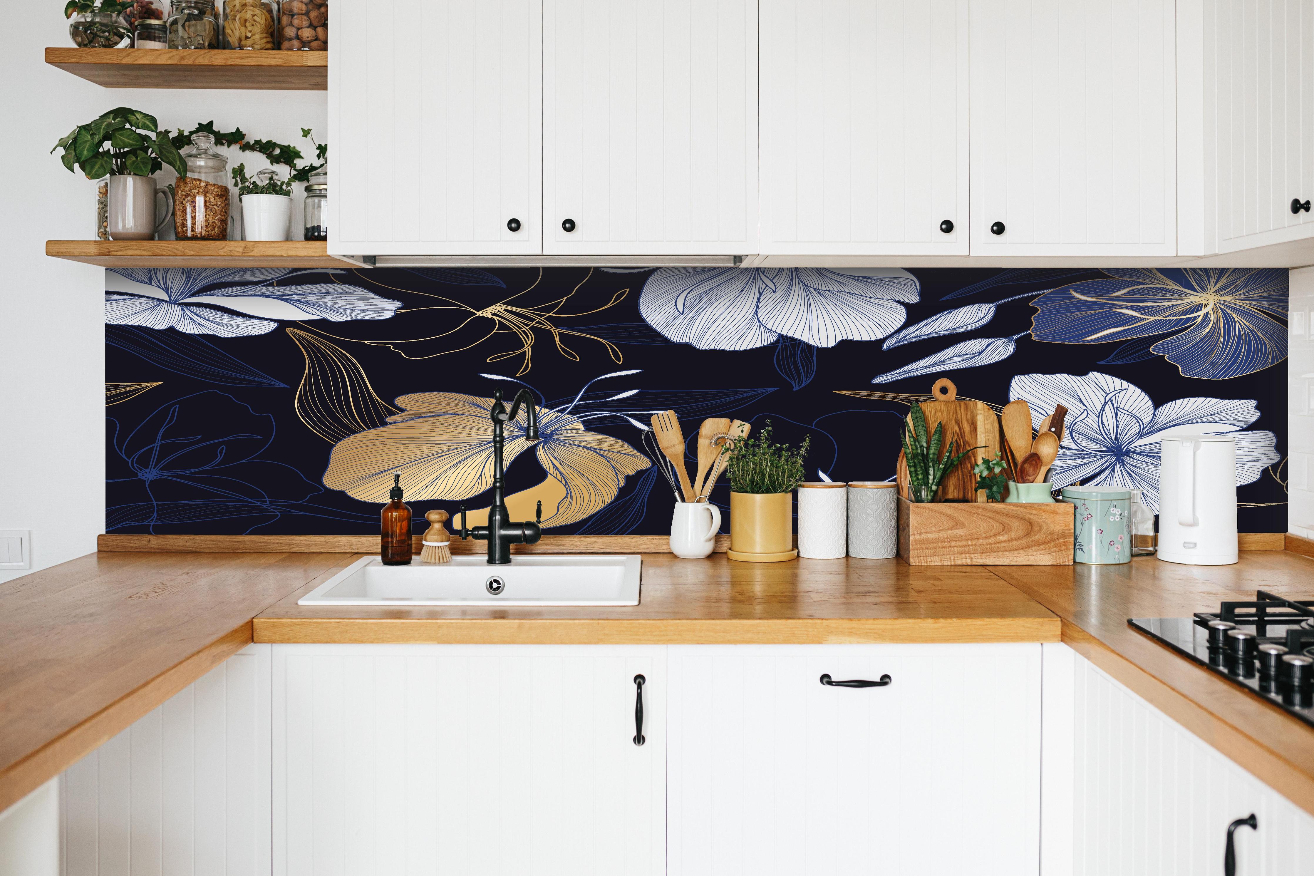 Küche - Goldene Blumenillustration auf Dunkelblau hinter weißen Hochglanz-Küchenregalen und schwarzem Wasserhahn