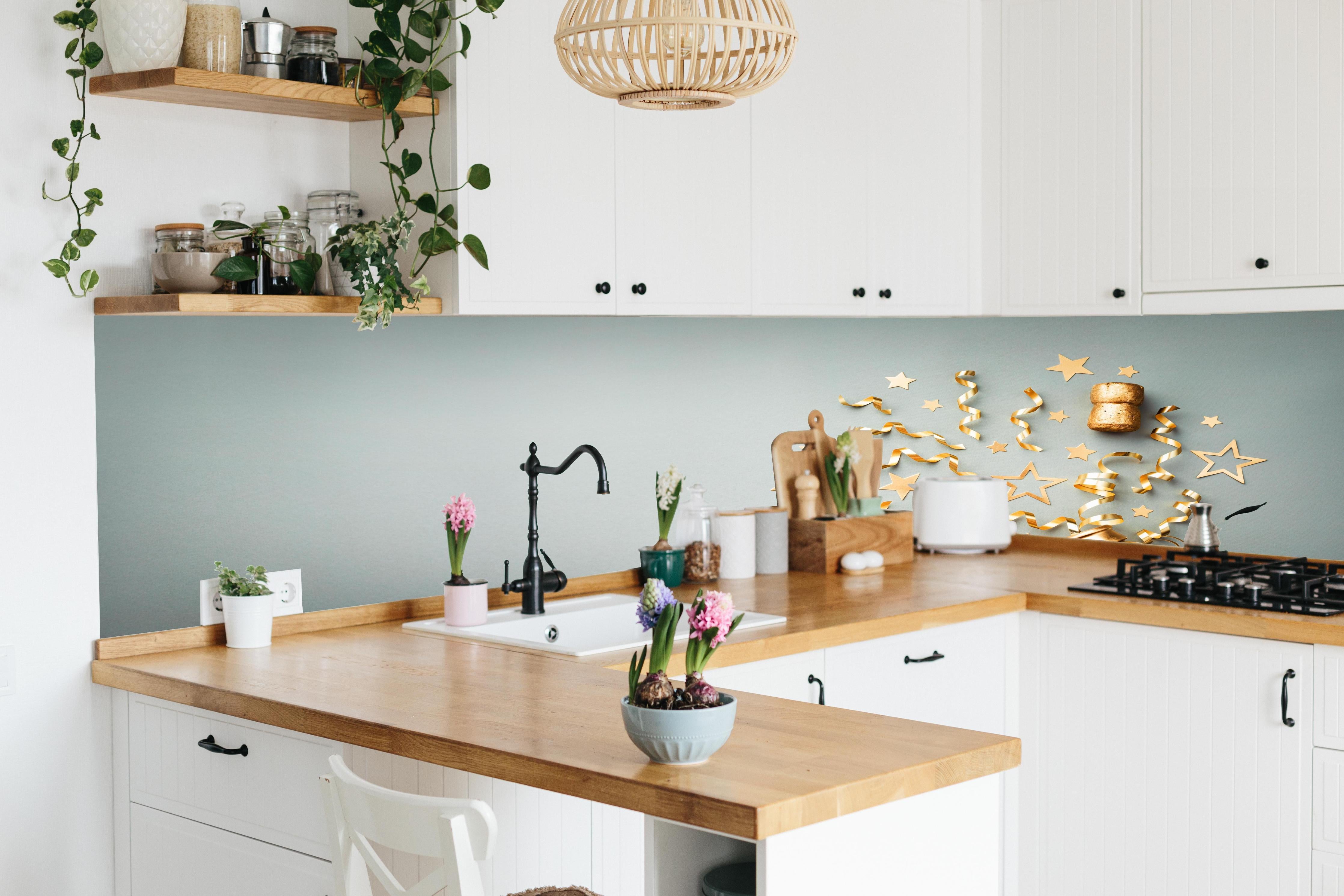 Küche - Goldene Champagnerflasche im Sylvester design hinter weißen Hochglanz-Küchenregalen und schwarzem Wasserhahn