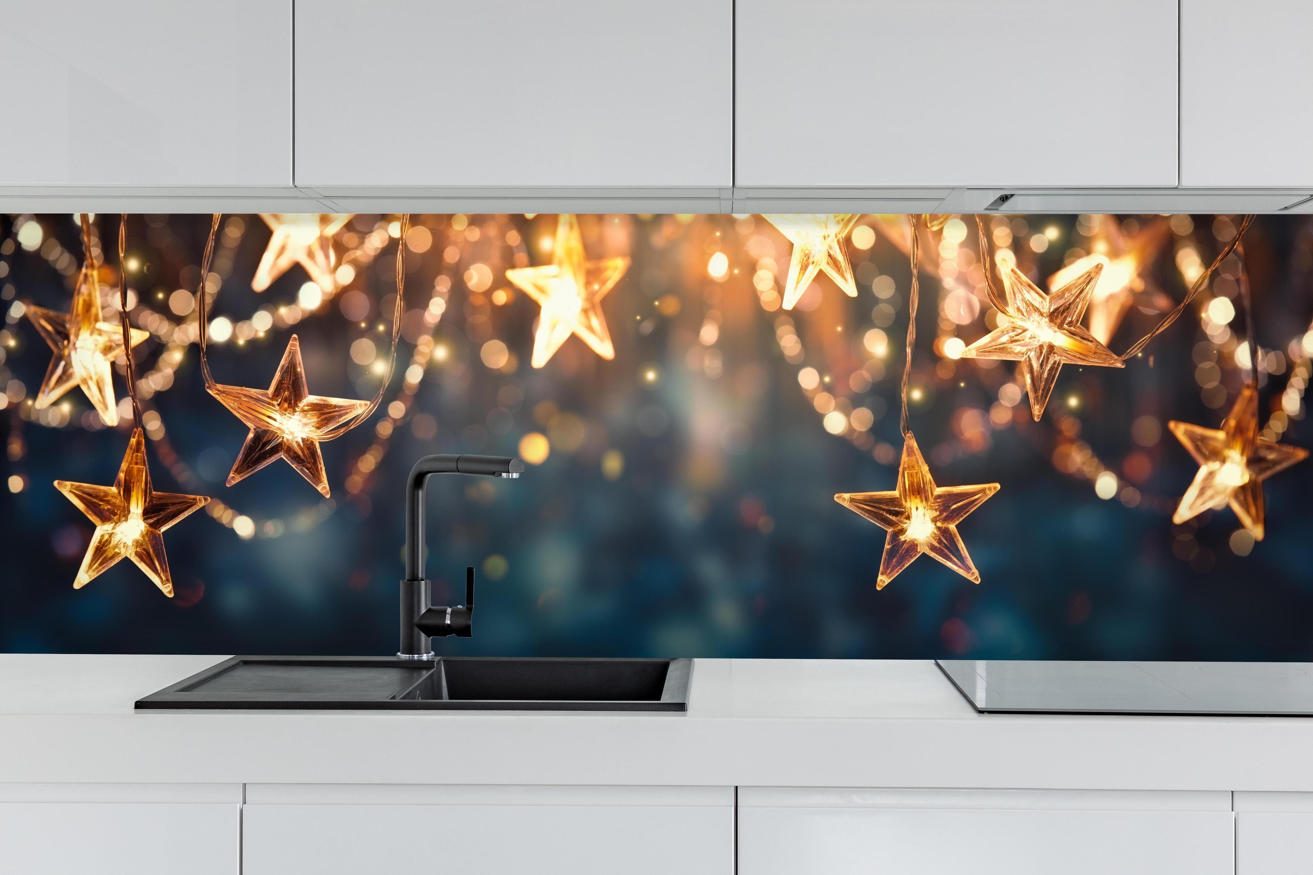 Küche - Goldene Sternen Lichterkette hinter weißen Hochglanz-Küchenregalen und schwarzem Wasserhahn
