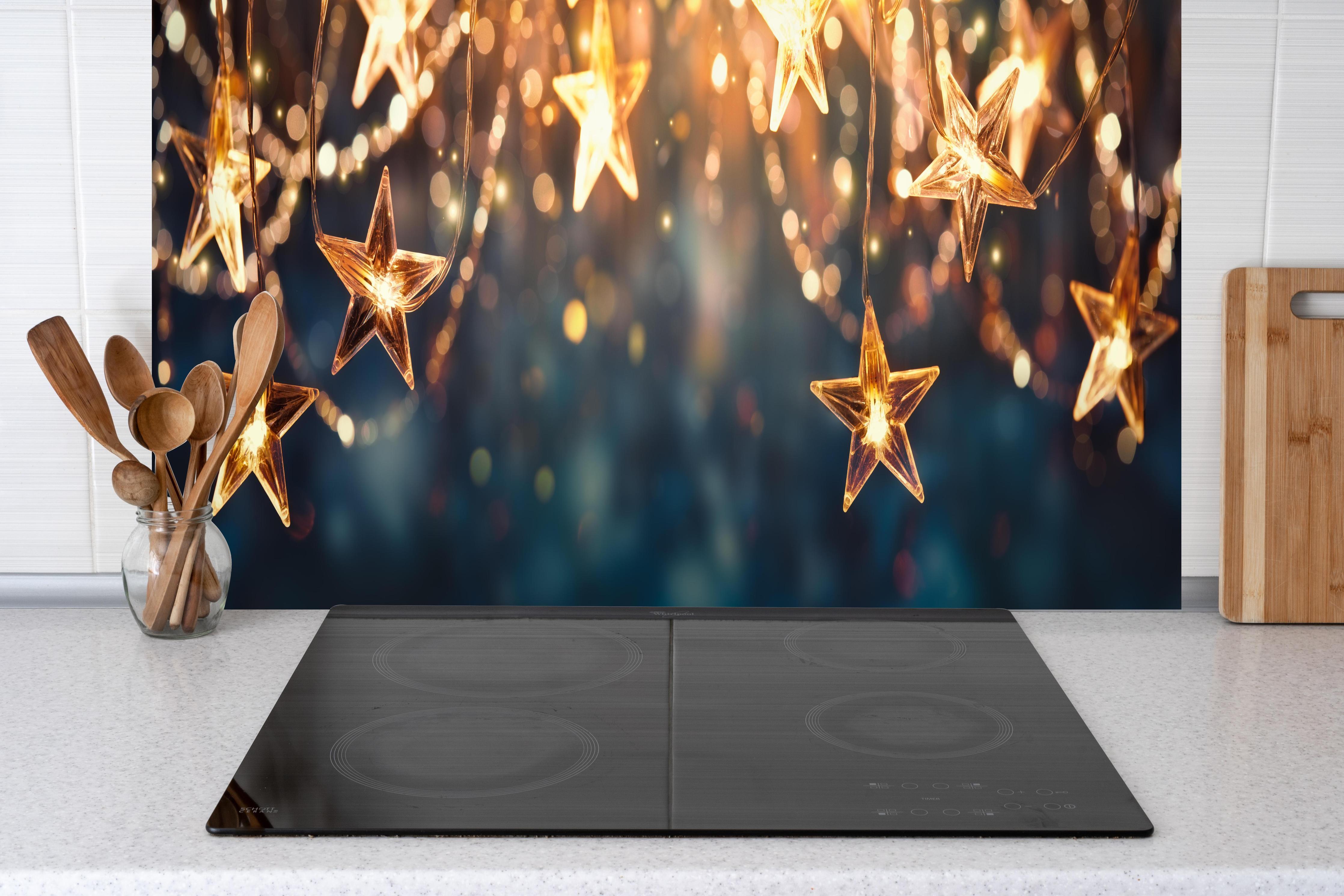 Küche - Goldene Sternen Lichterkette hinter weißen Hochglanz-Küchenregalen und schwarzem Wasserhahn