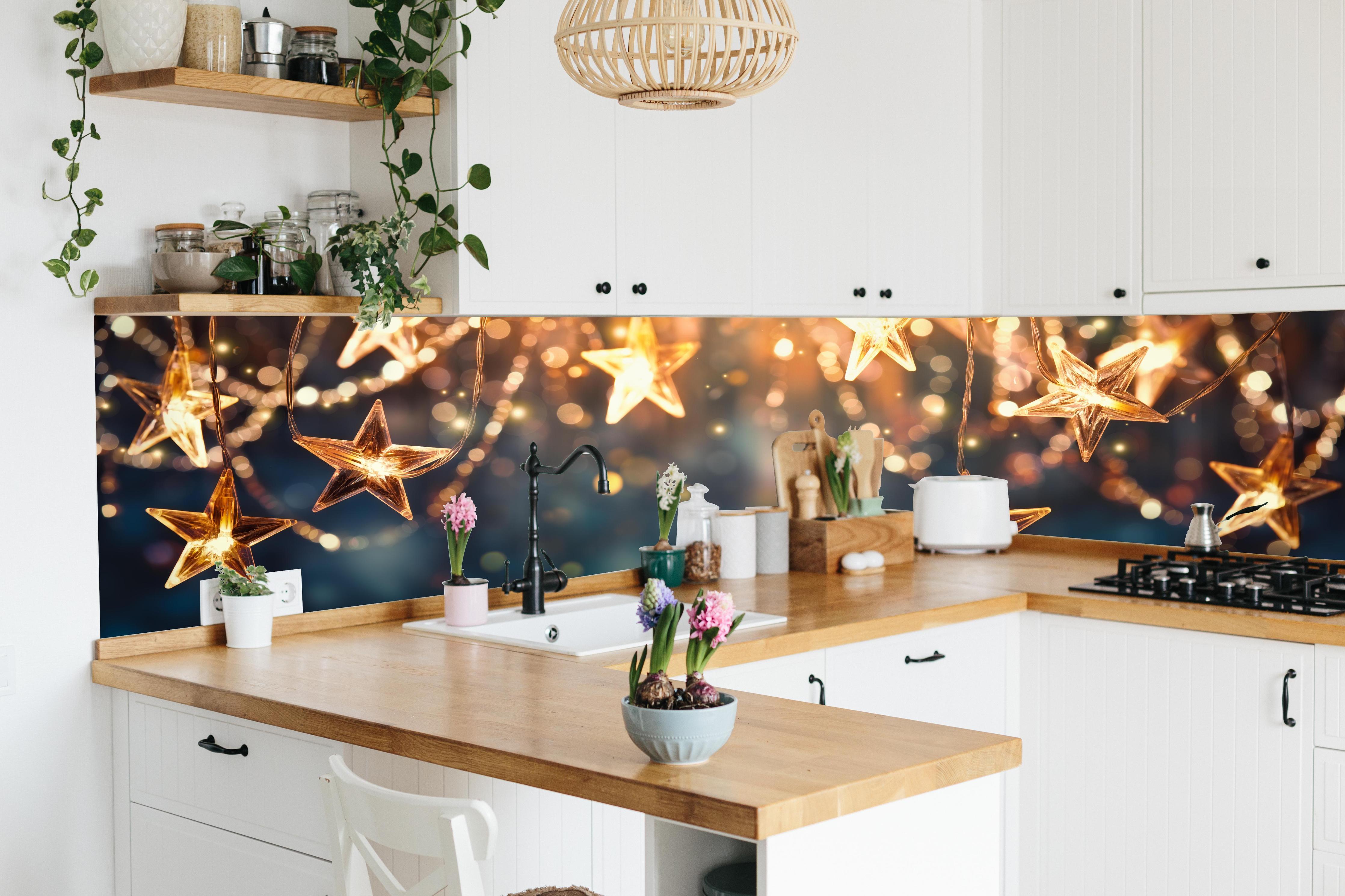 Küche - Goldene Sternen Lichterkette hinter weißen Hochglanz-Küchenregalen und schwarzem Wasserhahn