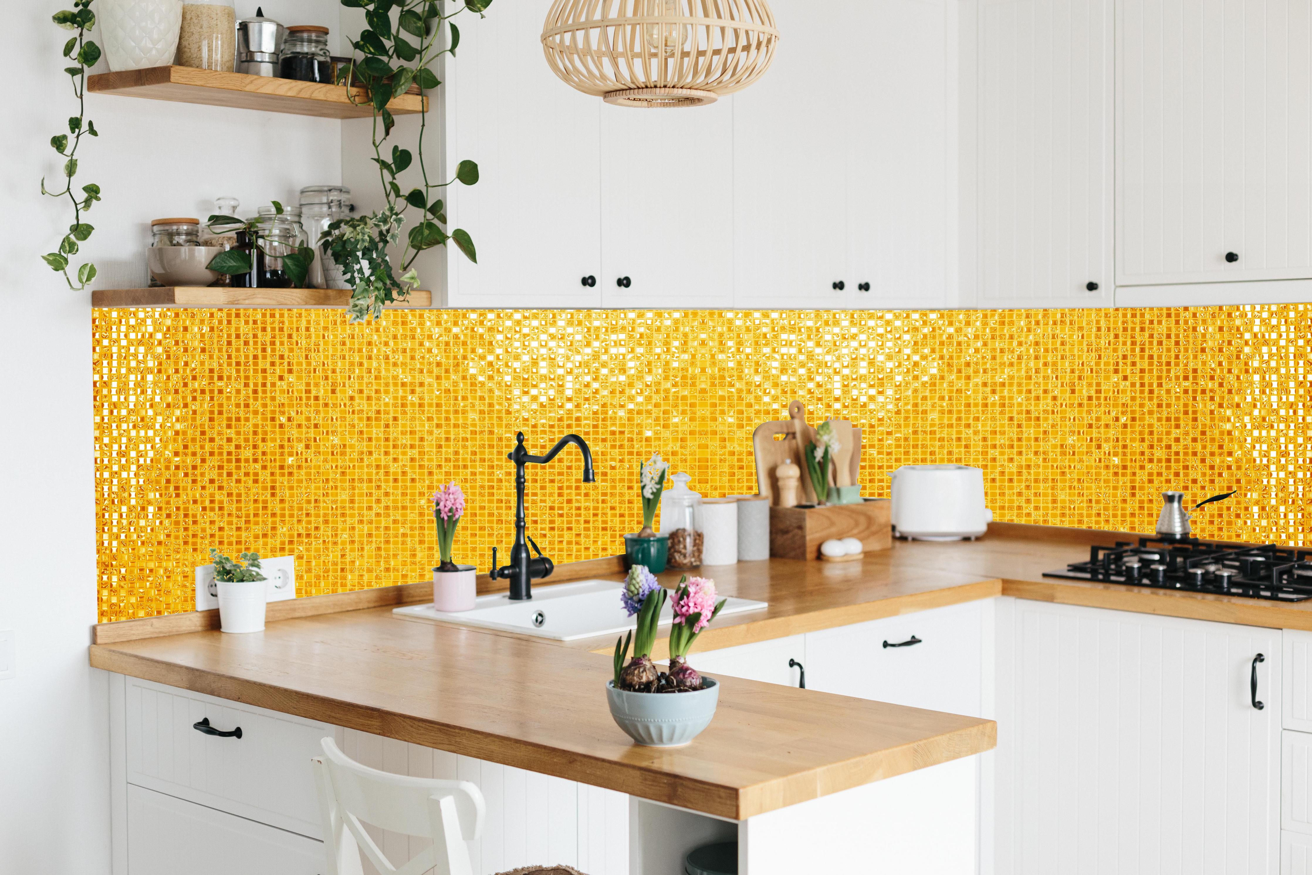 Küche - Goldgelbe Mosaikfliesen hinter weißen Hochglanz-Küchenregalen und schwarzem Wasserhahn