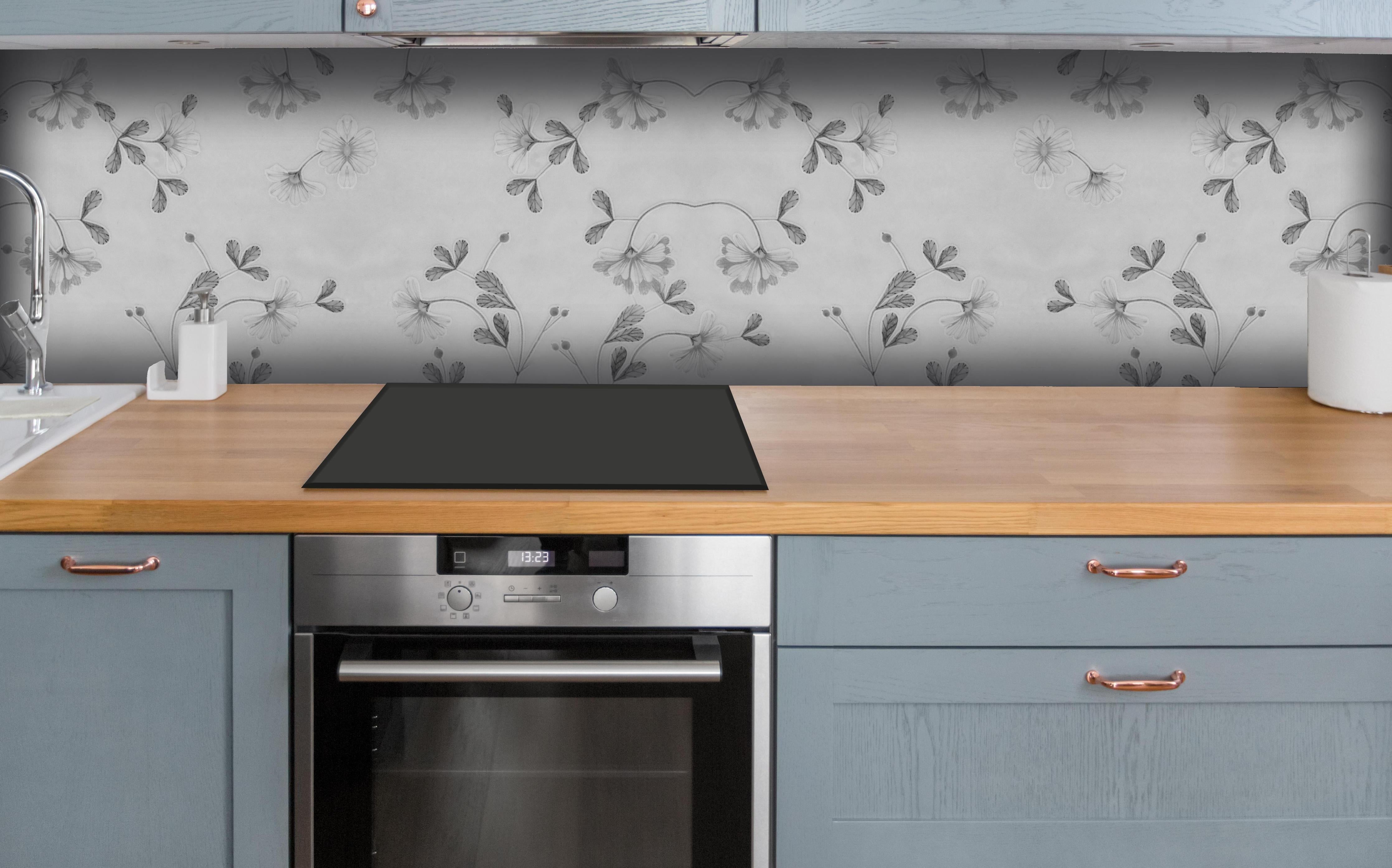 Küche - Grau-Weißes Blumenmuster auf Textil hinter weißen Hochglanz-Küchenregalen und schwarzem Wasserhahn