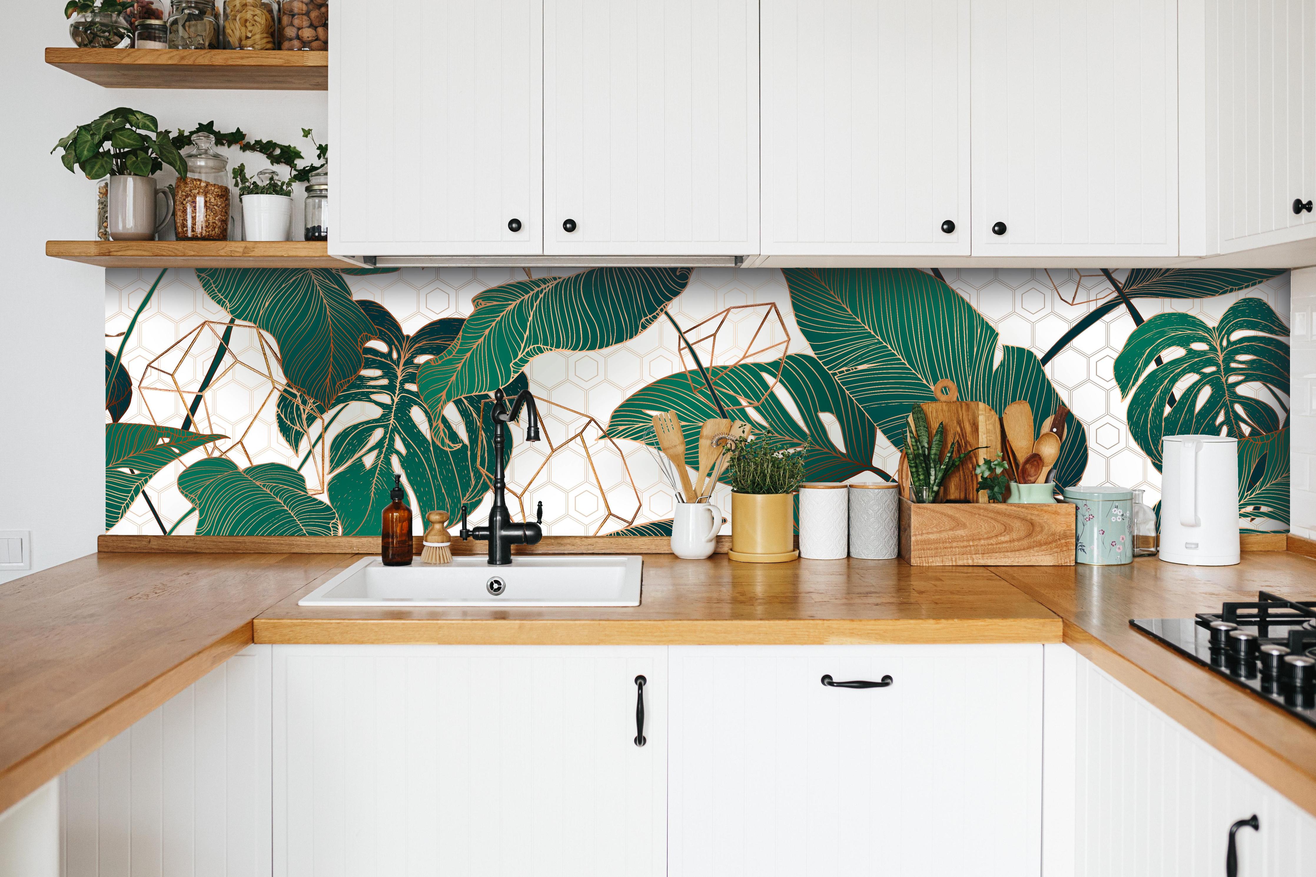 Küche - Grüne Blätter auf eleganter Tapete hinter weißen Hochglanz-Küchenregalen und schwarzem Wasserhahn