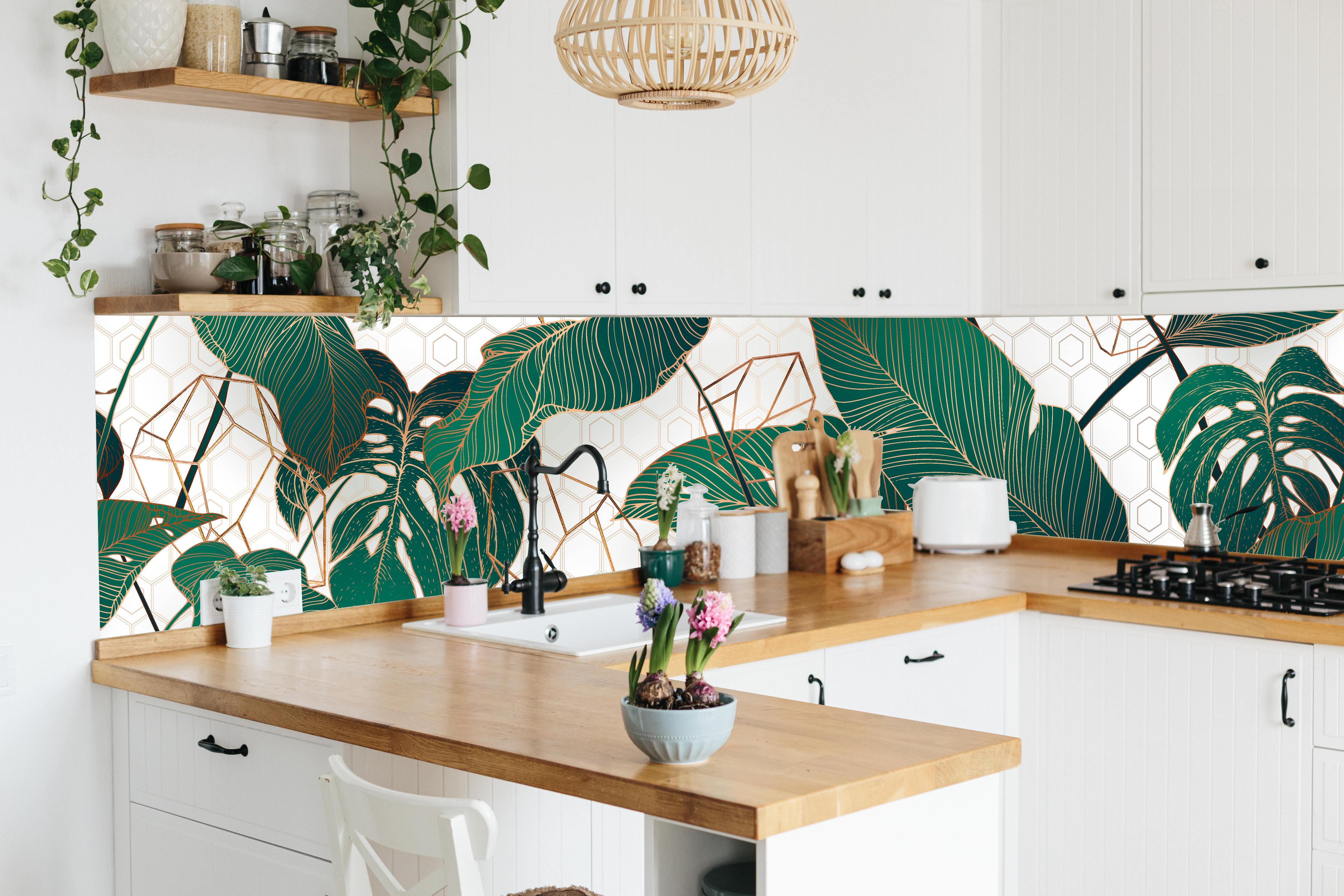 Küche - Grüne Blätter auf eleganter Tapete hinter weißen Hochglanz-Küchenregalen und schwarzem Wasserhahn