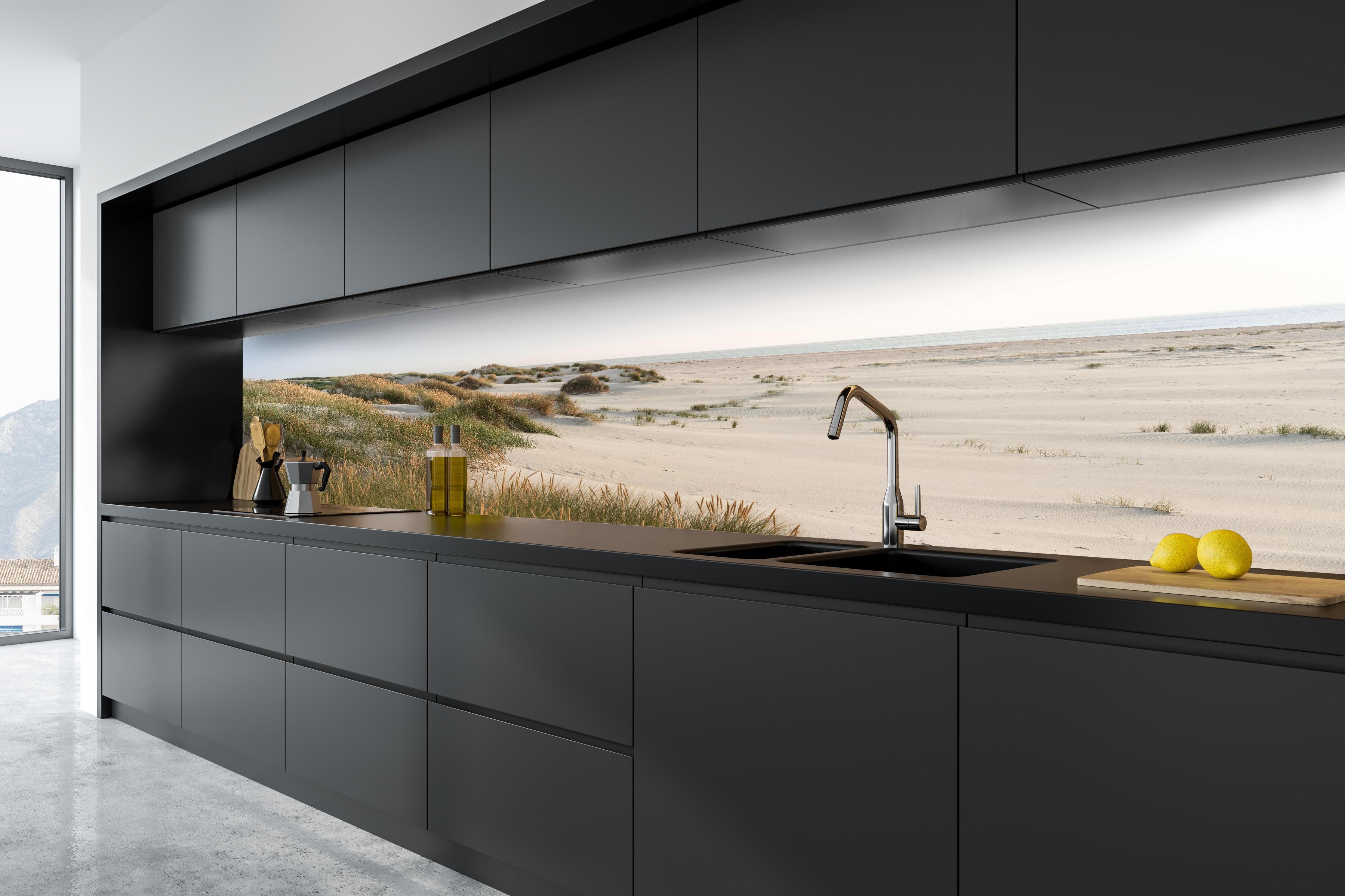 Küche - Harmonische Strandlandschaft mit sanften Sanddünen und Strandgräsern hinter weißen Hochglanz-Küchenregalen und schwarzem Wasserhahn