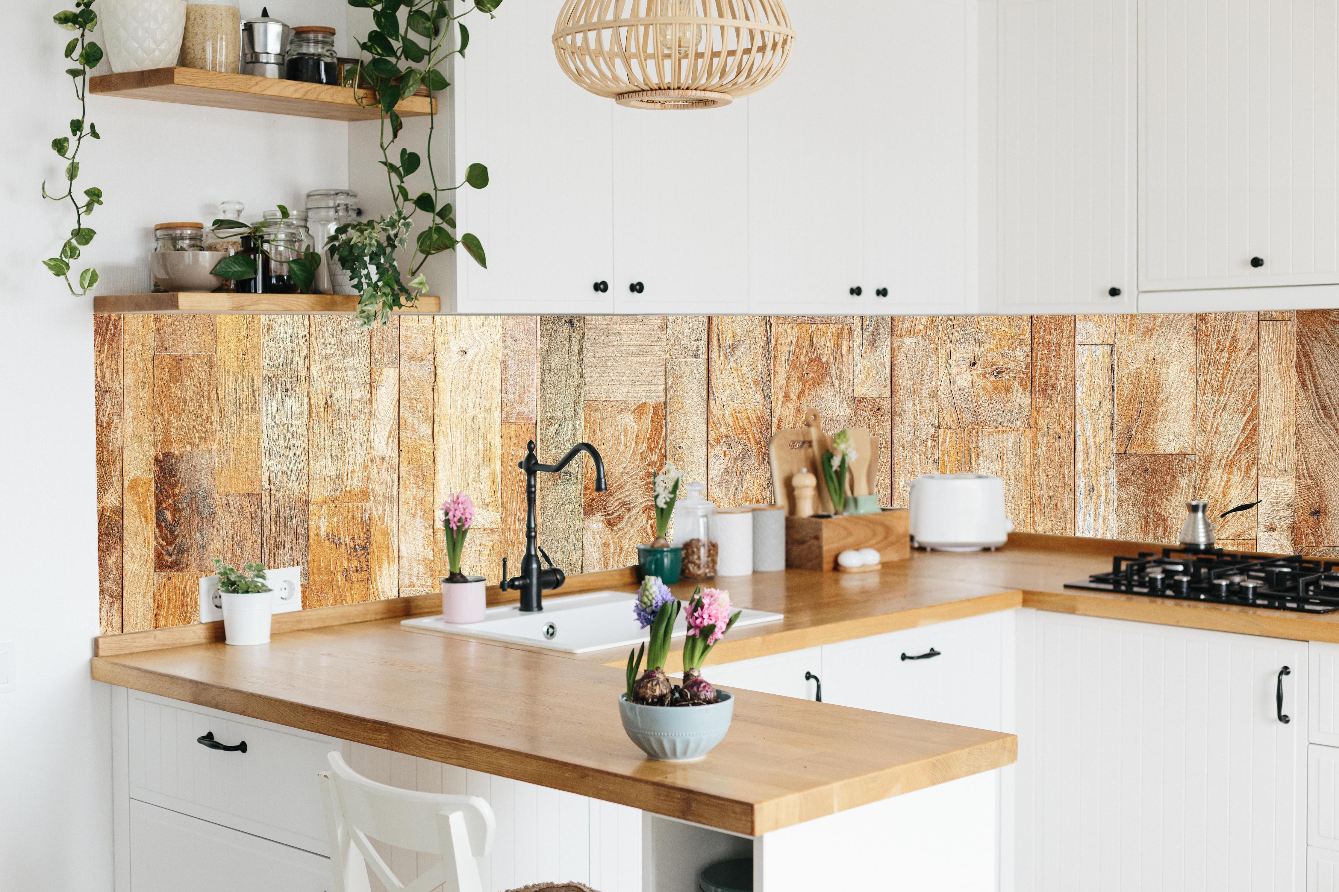 Küche - Heller Holzhintergrund hinter weißen Hochglanz-Küchenregalen und schwarzem Wasserhahn