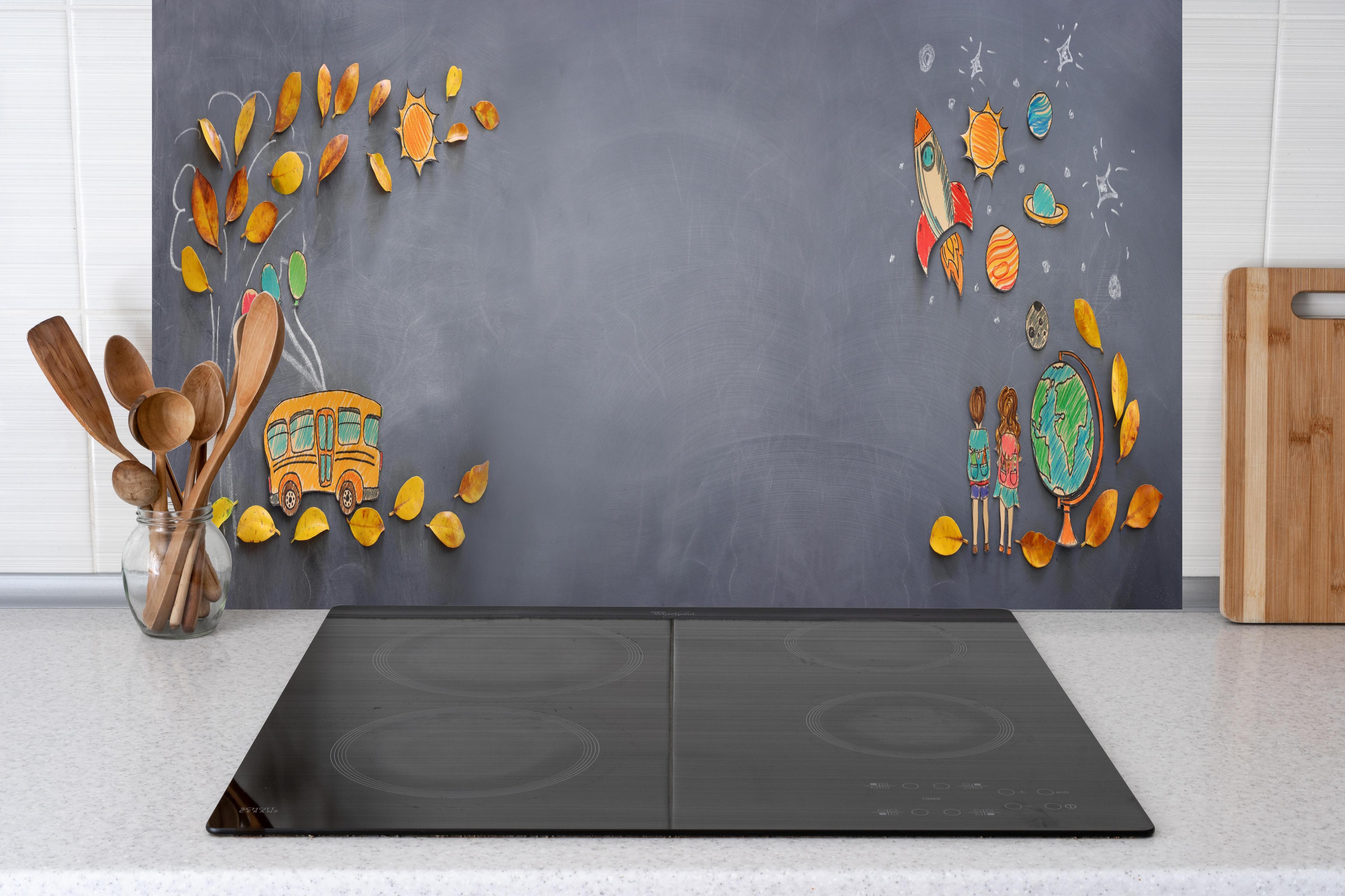 Küche - Herbstleaves und Schulbus auf Tafel hinter weißen Hochglanz-Küchenregalen und schwarzem Wasserhahn