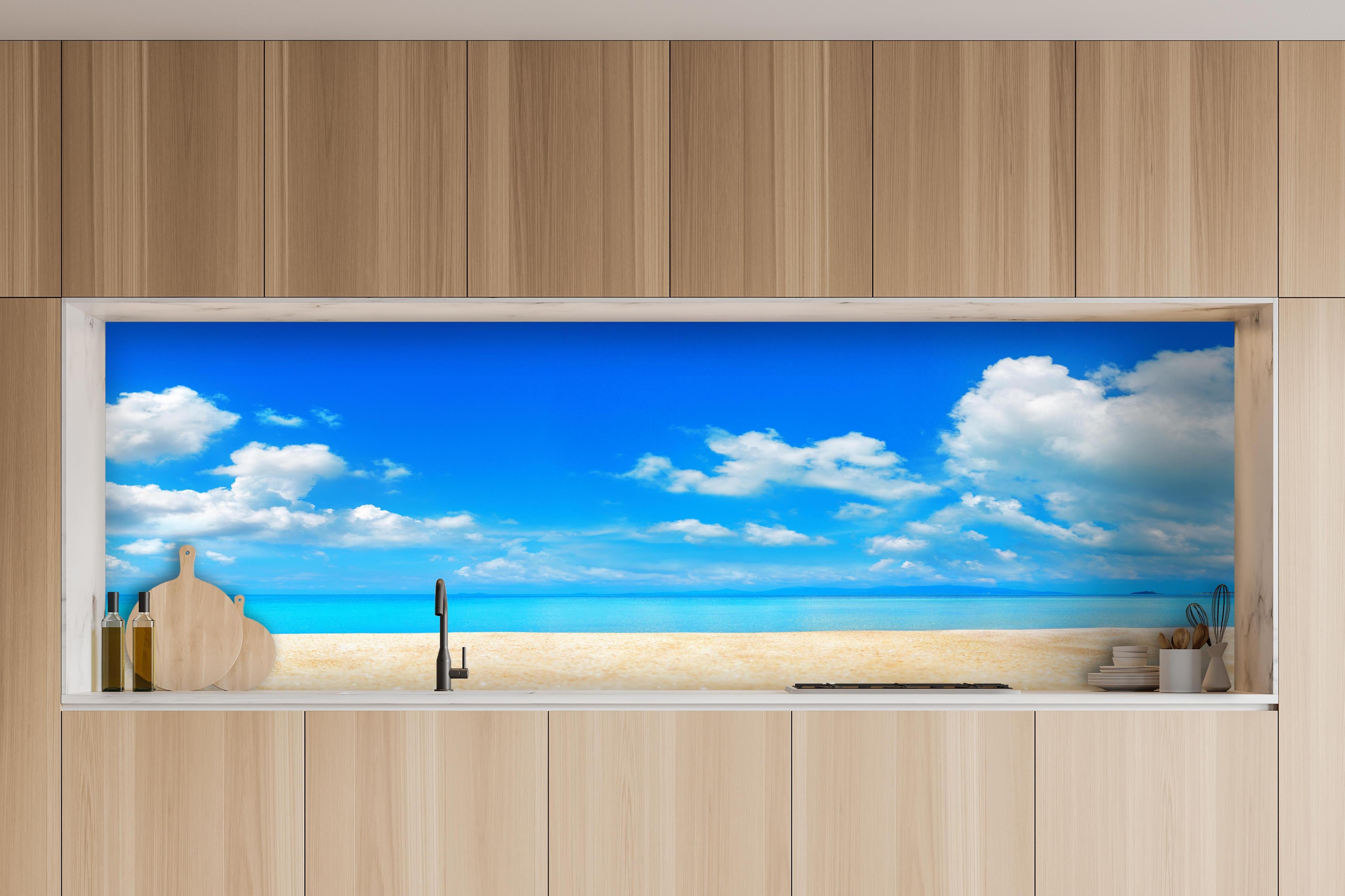 Küche - Idyllische Strandlandschaft mit klarem Wasser und blauem Himmel hinter weißen Hochglanz-Küchenregalen und schwarzem Wasserhahn