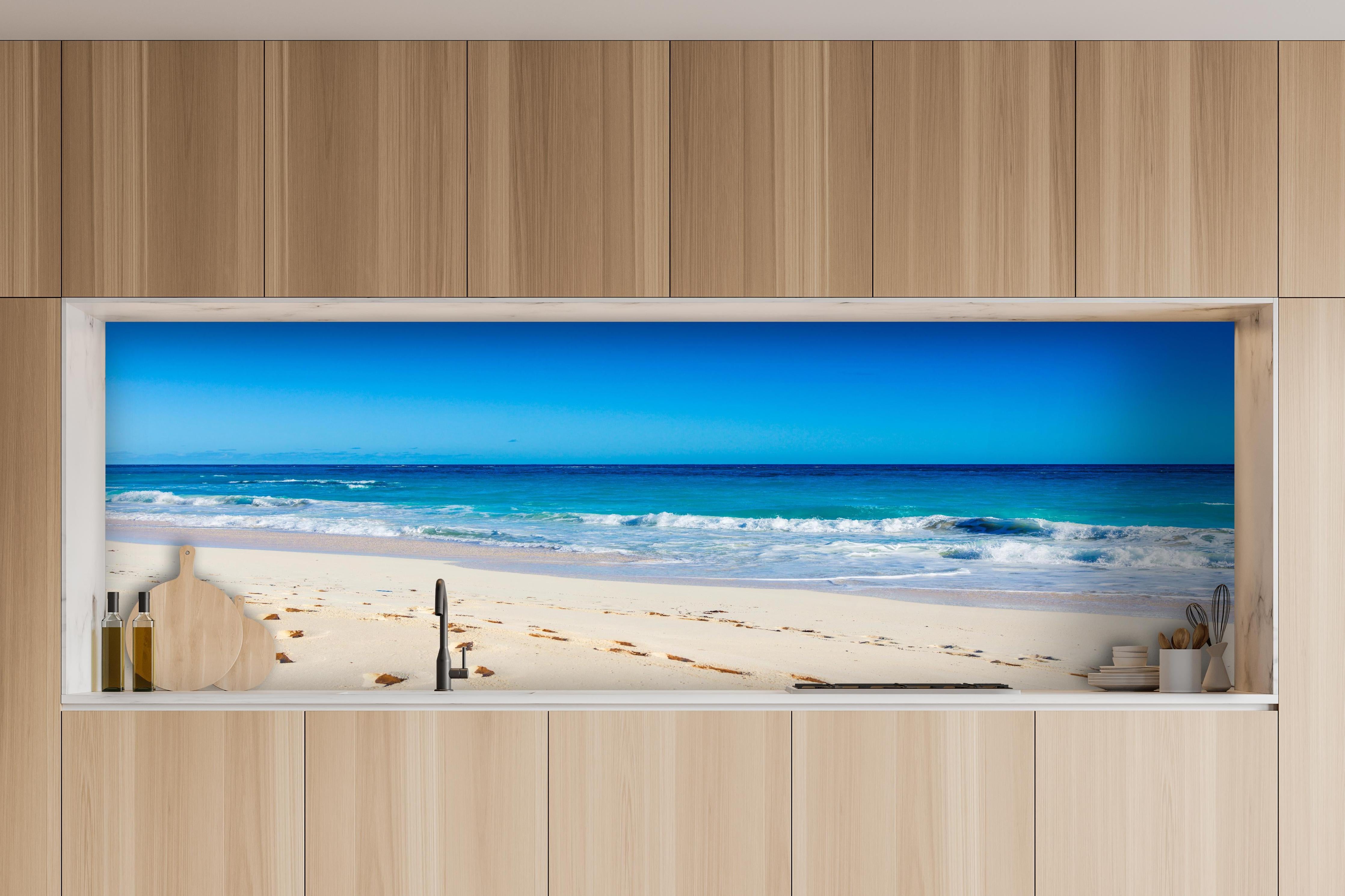 Küche - Idyllischer Strand mit feinem Sand und türkisfarbenem Wasser hinter weißen Hochglanz-Küchenregalen und schwarzem Wasserhahn