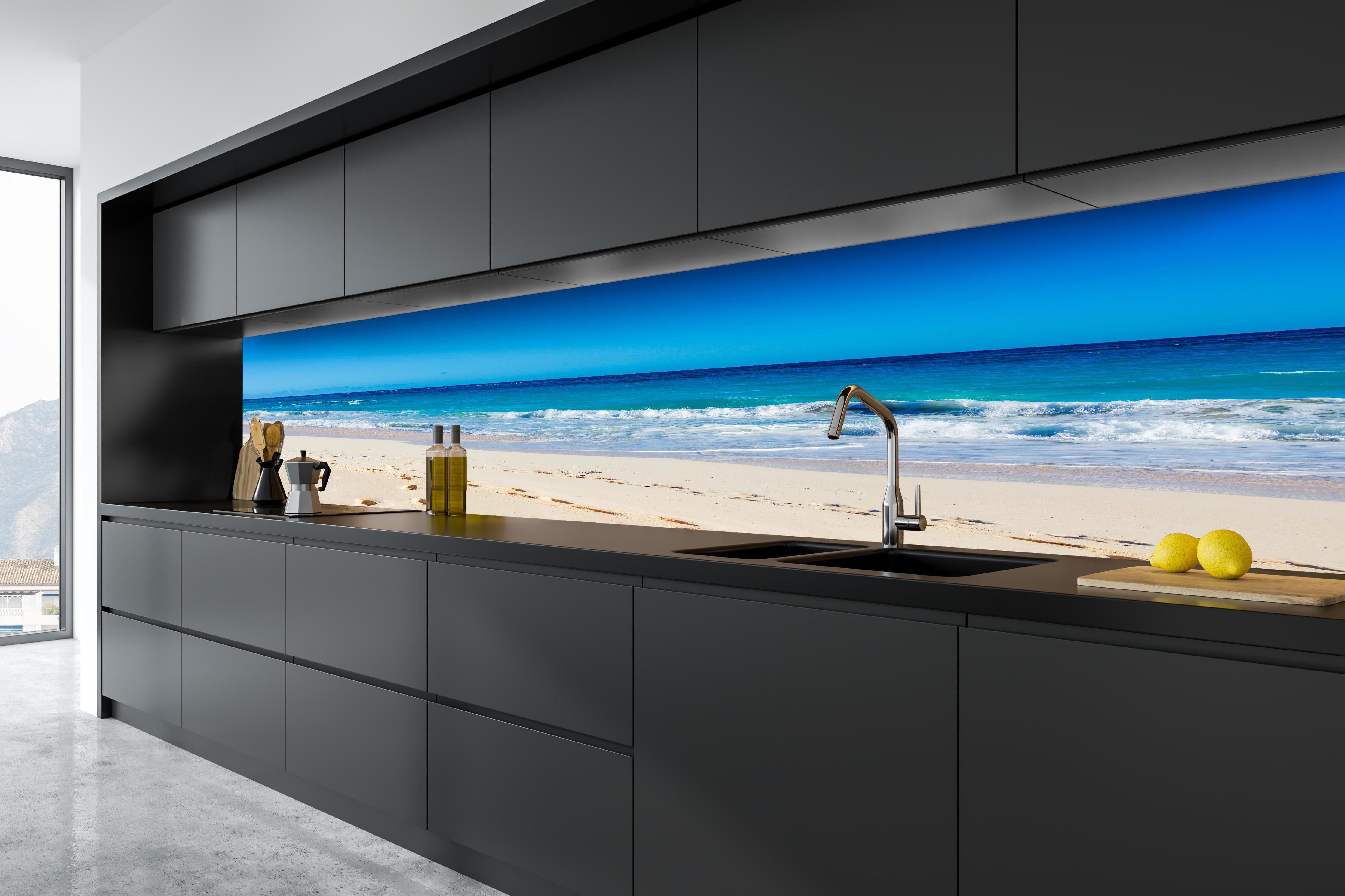 Küche - Idyllischer Strand mit feinem Sand und türkisfarbenem Wasser hinter weißen Hochglanz-Küchenregalen und schwarzem Wasserhahn