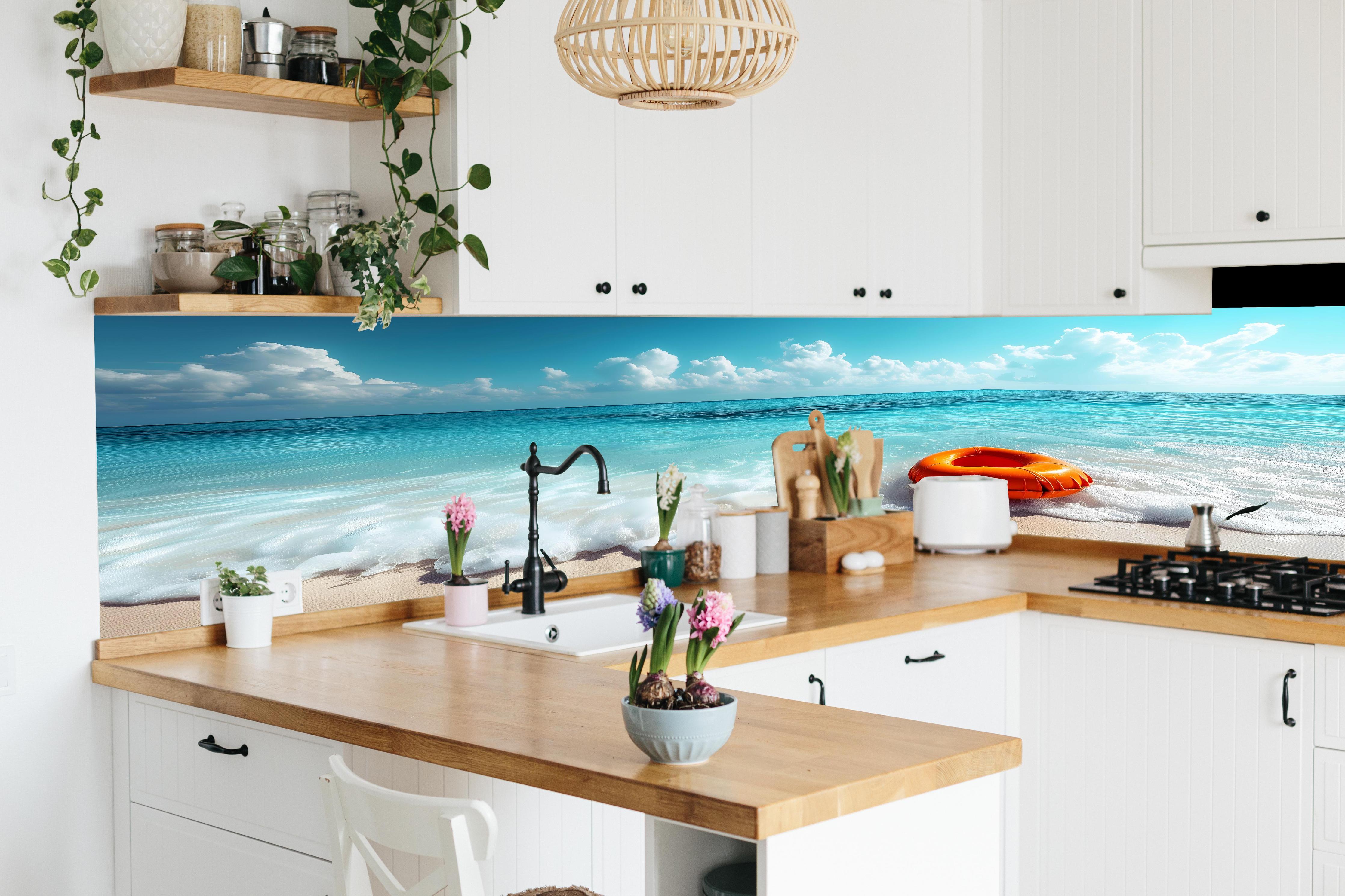 Küche - Idyllischer Strand mit orangefarbener Schwimmringen und klarblauem Wasser hinter weißen Hochglanz-Küchenregalen und schwarzem Wasserhahn