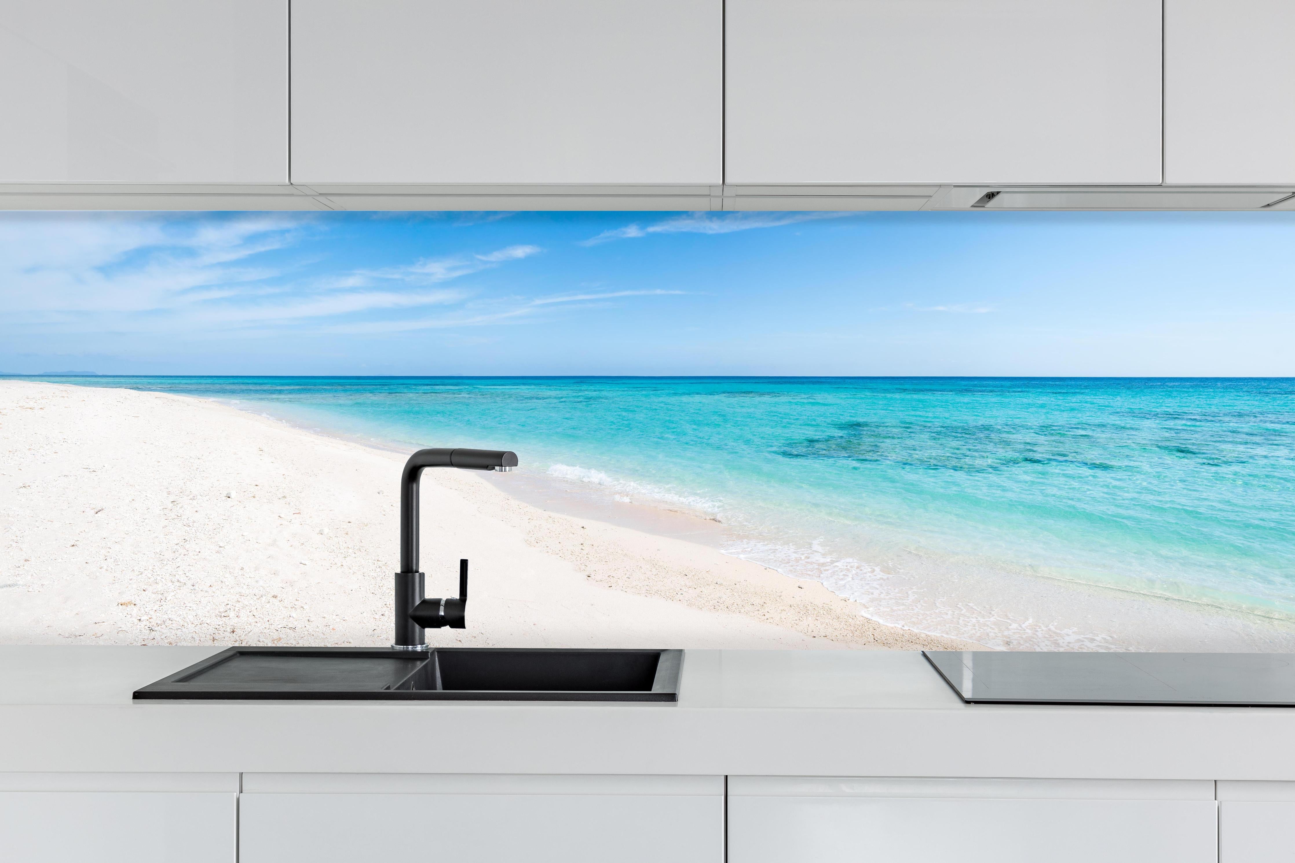 Küche - Idyllischer karibischer Strand mit strahlend blauem Wasser und feinem Sand hinter weißen Hochglanz-Küchenregalen und schwarzem Wasserhahn