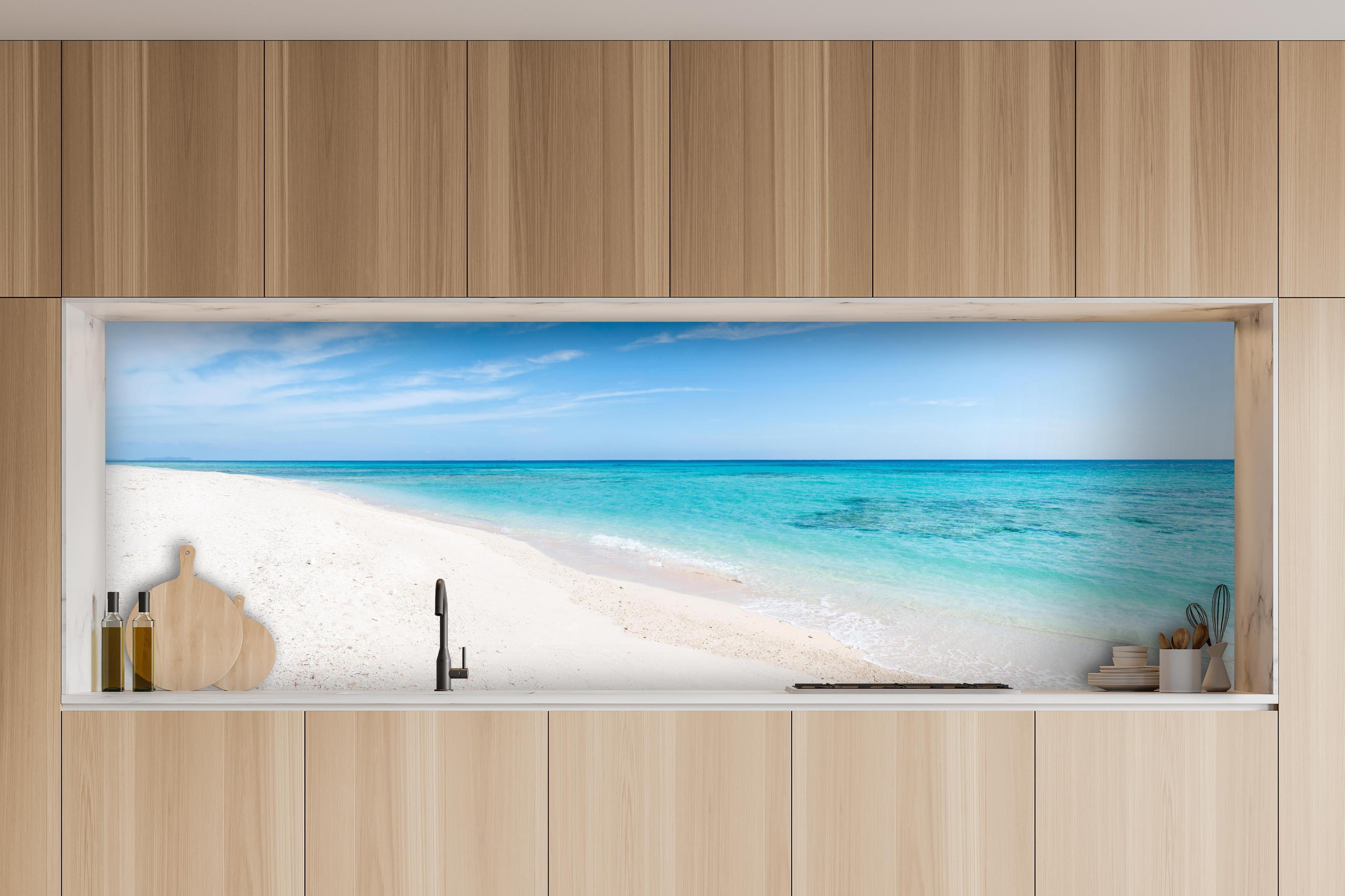 Küche - Idyllischer karibischer Strand mit strahlend blauem Wasser und feinem Sand hinter weißen Hochglanz-Küchenregalen und schwarzem Wasserhahn