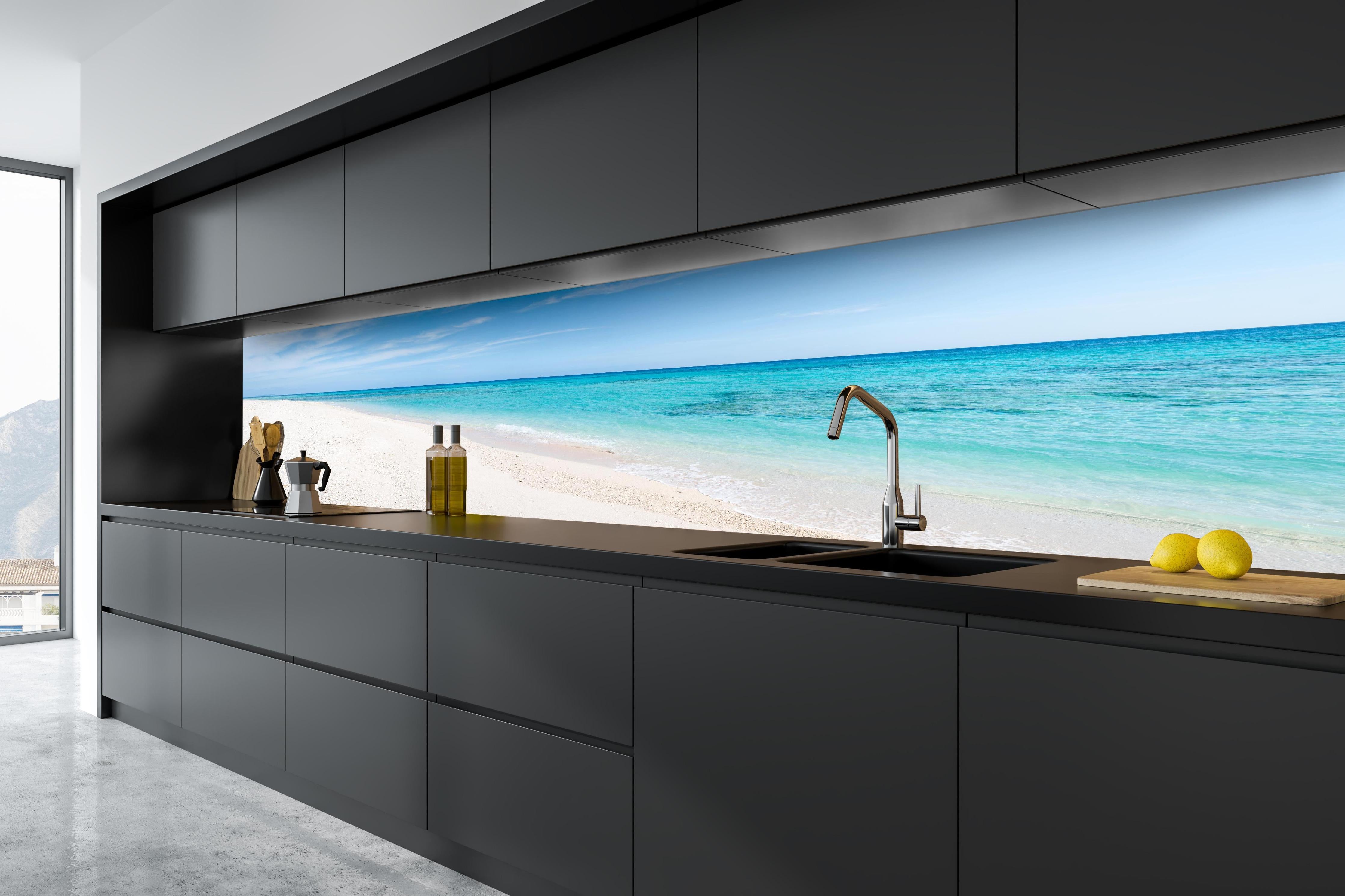 Küche - Idyllischer karibischer Strand mit strahlend blauem Wasser und feinem Sand hinter weißen Hochglanz-Küchenregalen und schwarzem Wasserhahn