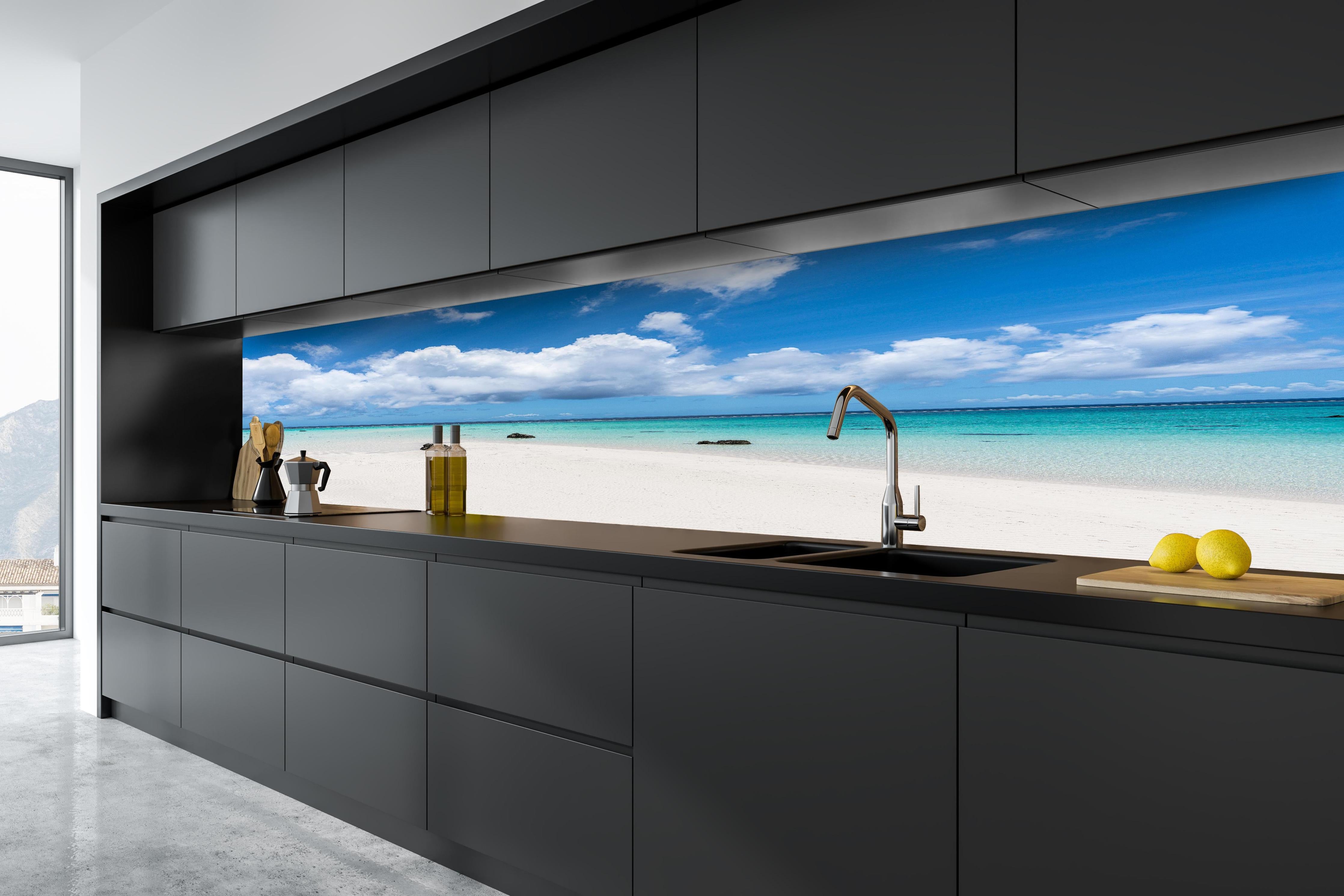 Küche - Idyllischer tropischer Strand mit kristallklarem Wasser und Wolkenhimmel hinter weißen Hochglanz-Küchenregalen und schwarzem Wasserhahn