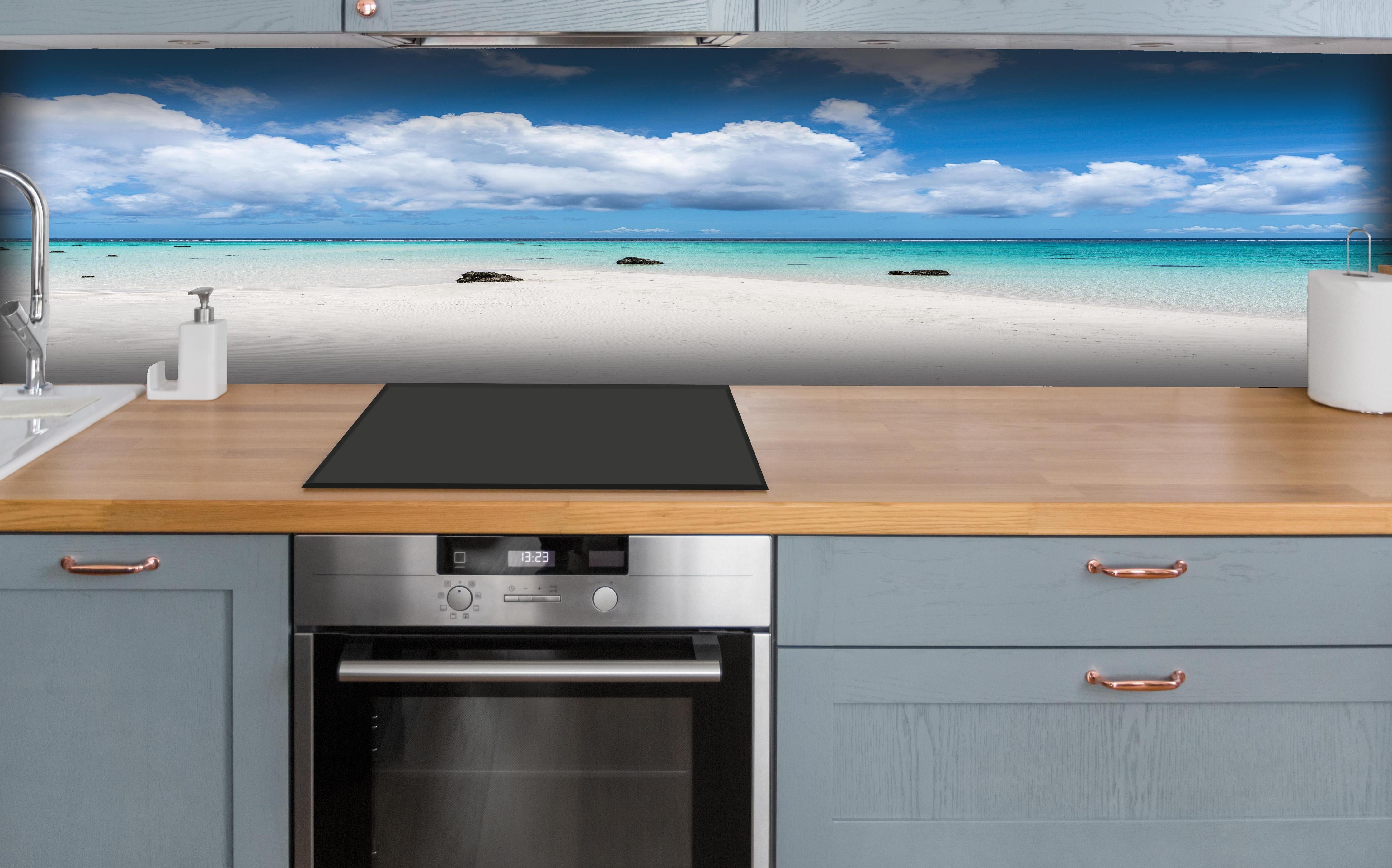 Küche - Idyllischer tropischer Strand mit kristallklarem Wasser und Wolkenhimmel hinter weißen Hochglanz-Küchenregalen und schwarzem Wasserhahn