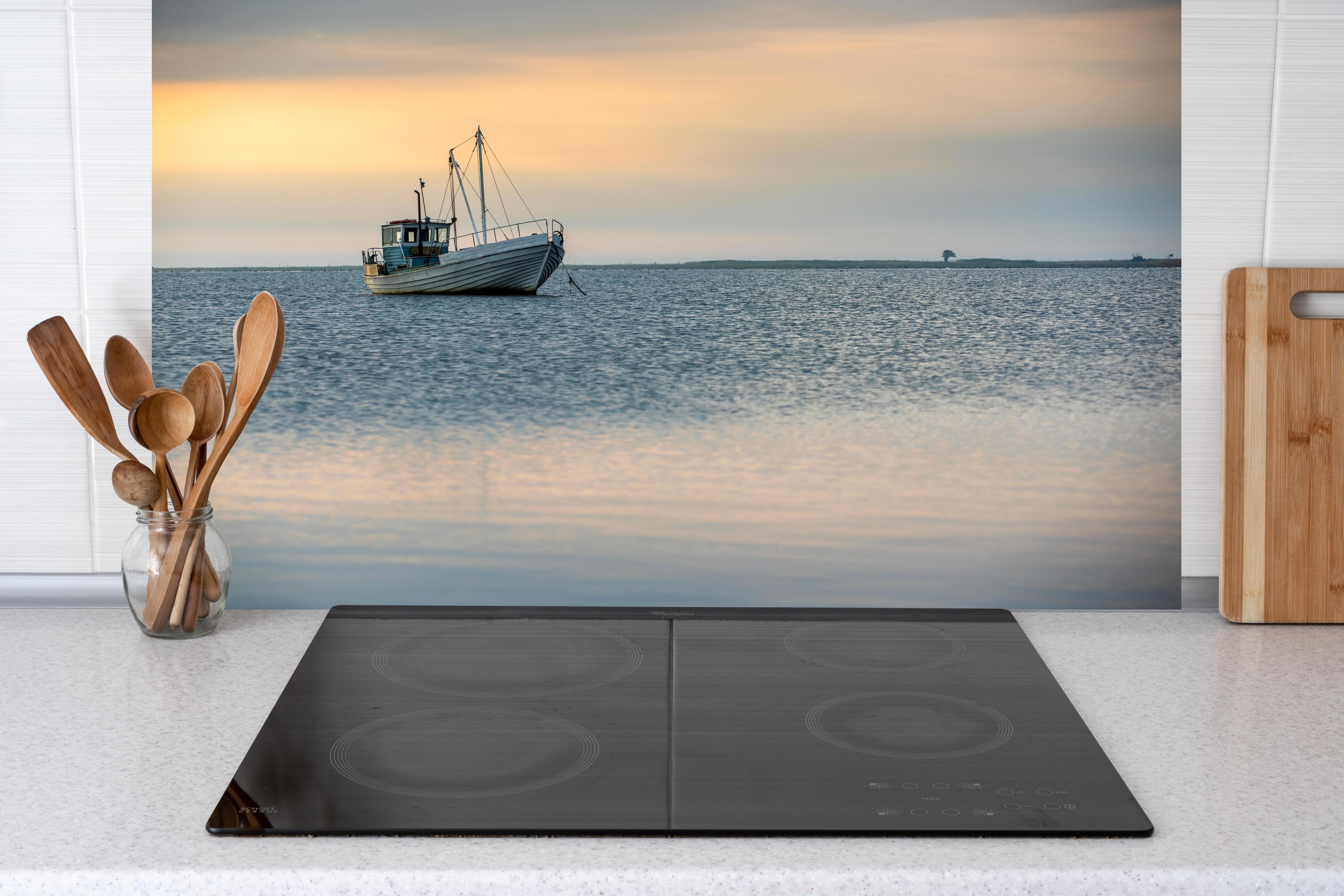 Küche - Idyllisches Boot auf ruhigem Wasser bei Sonnenuntergang hinter weißen Hochglanz-Küchenregalen und schwarzem Wasserhahn