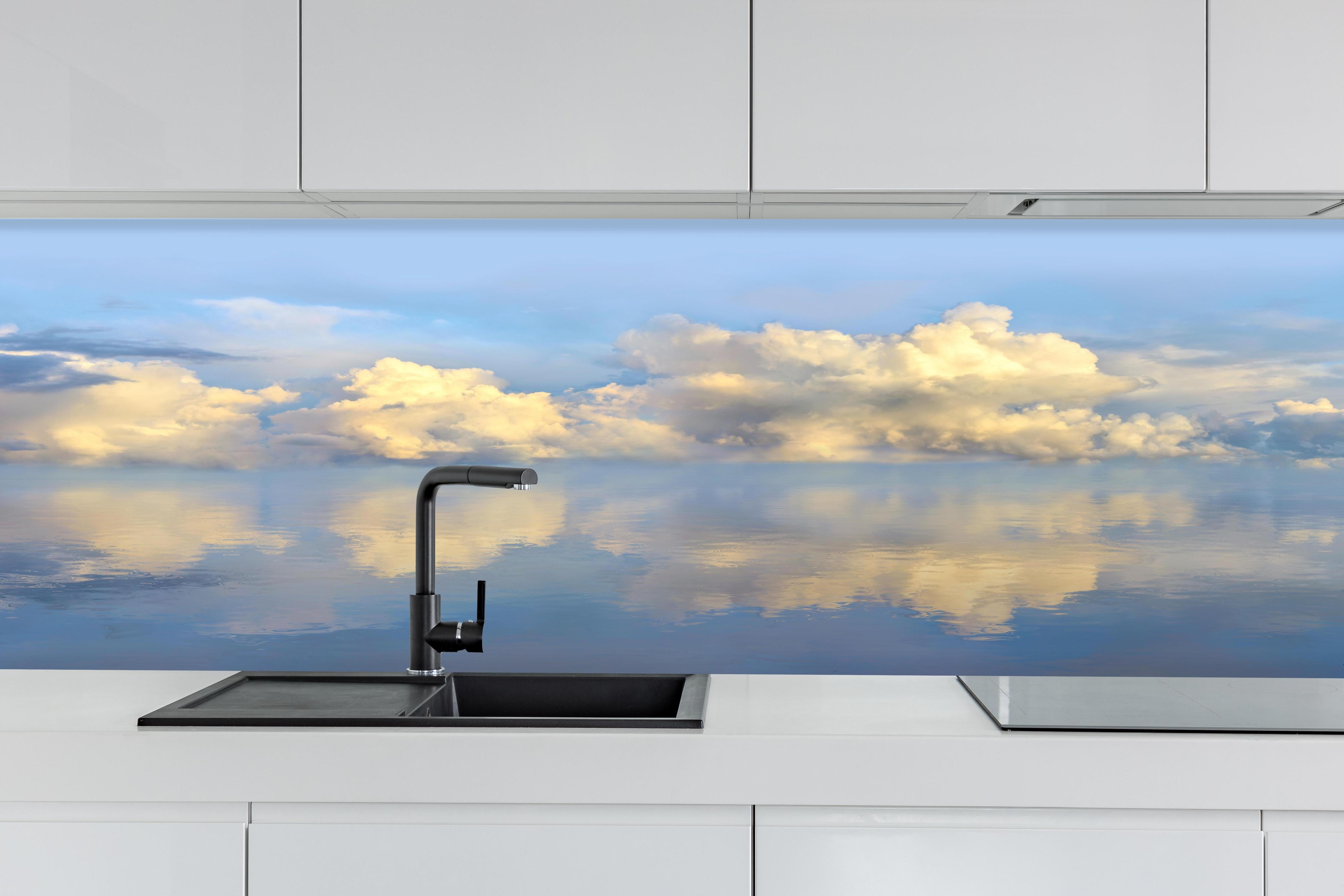Küche - Idyllisches Wolkenmeer mit leuchtenden Reflexionen auf ruhigem Wasser hinter weißen Hochglanz-Küchenregalen und schwarzem Wasserhahn