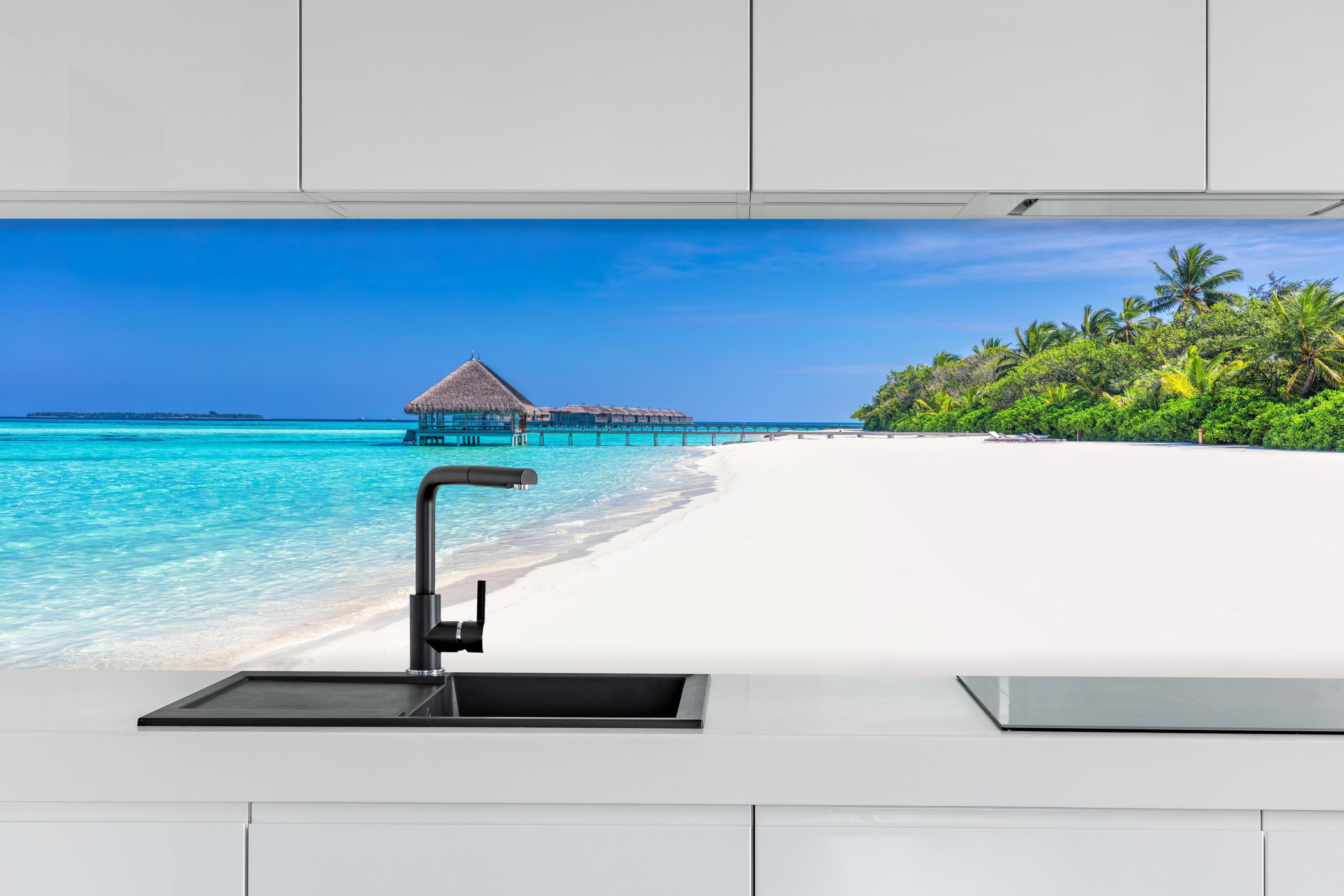Küche - Idyllisches tropisches Paradies mit türkisblauem Wasser und weißem Sandstrand hinter weißen Hochglanz-Küchenregalen und schwarzem Wasserhahn