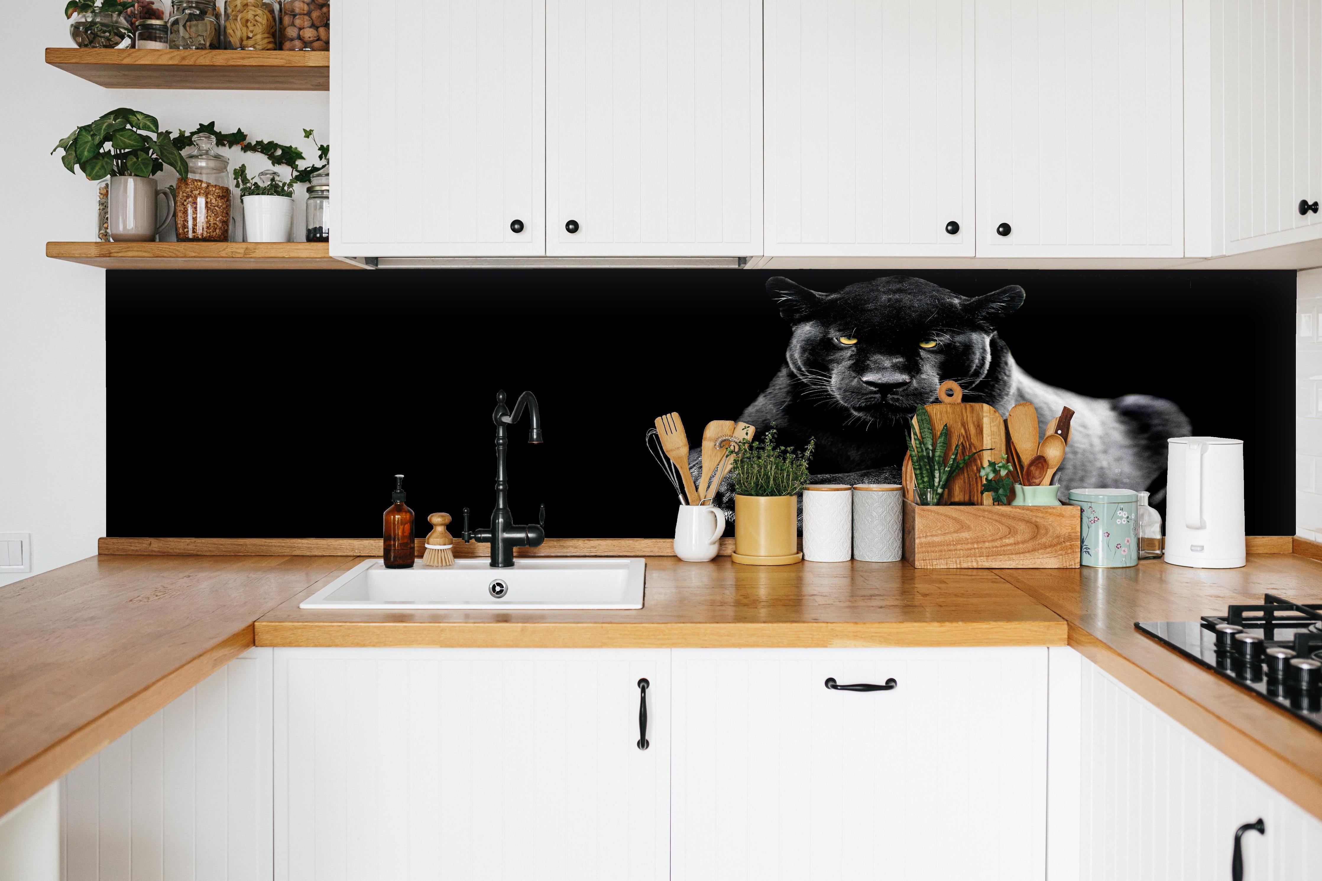 Küche - Jaguar auf schwarzem Hintergrund hinter weißen Hochglanz-Küchenregalen und schwarzem Wasserhahn