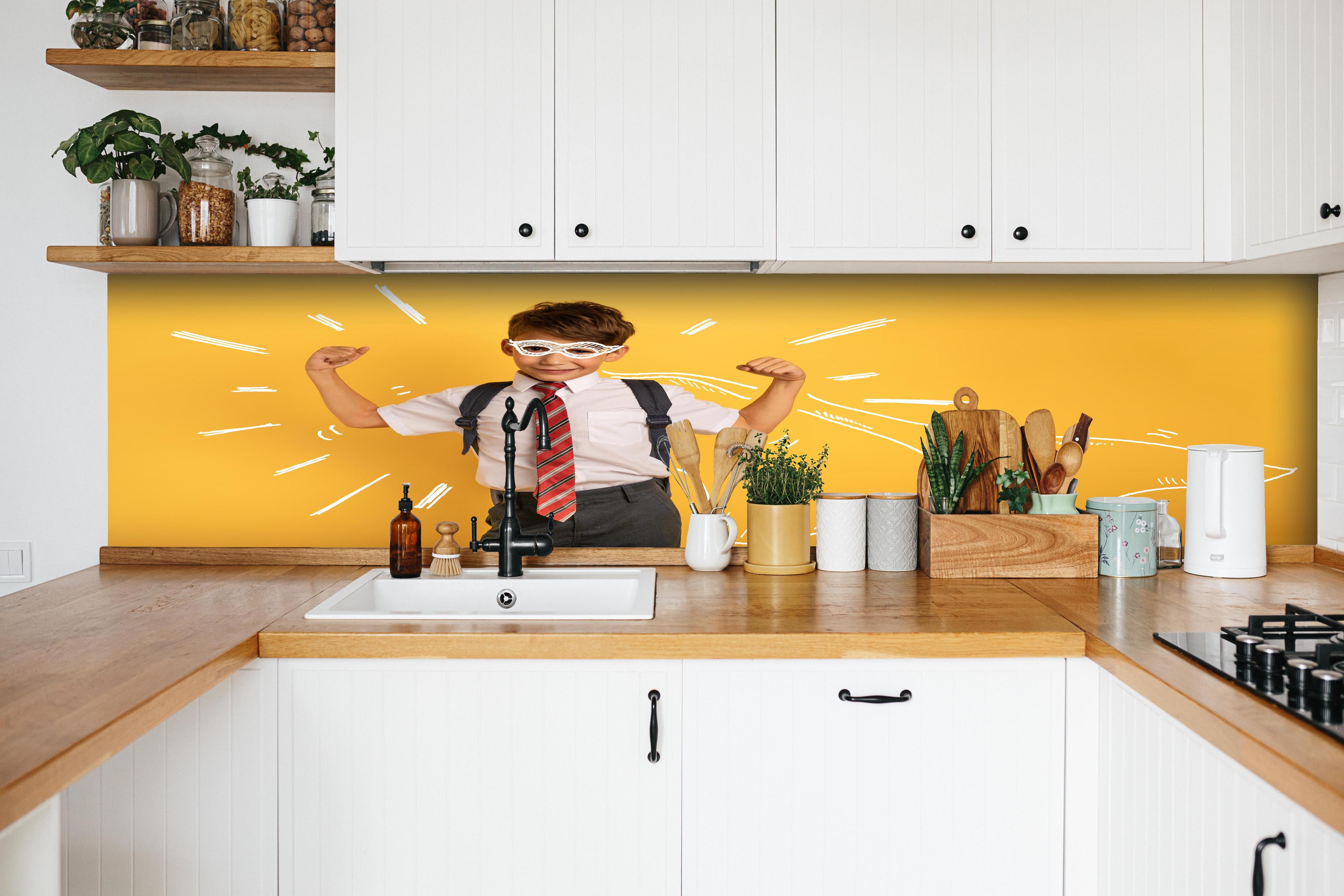 Küche - Junger Schüler hinter weißen Hochglanz-Küchenregalen und schwarzem Wasserhahn