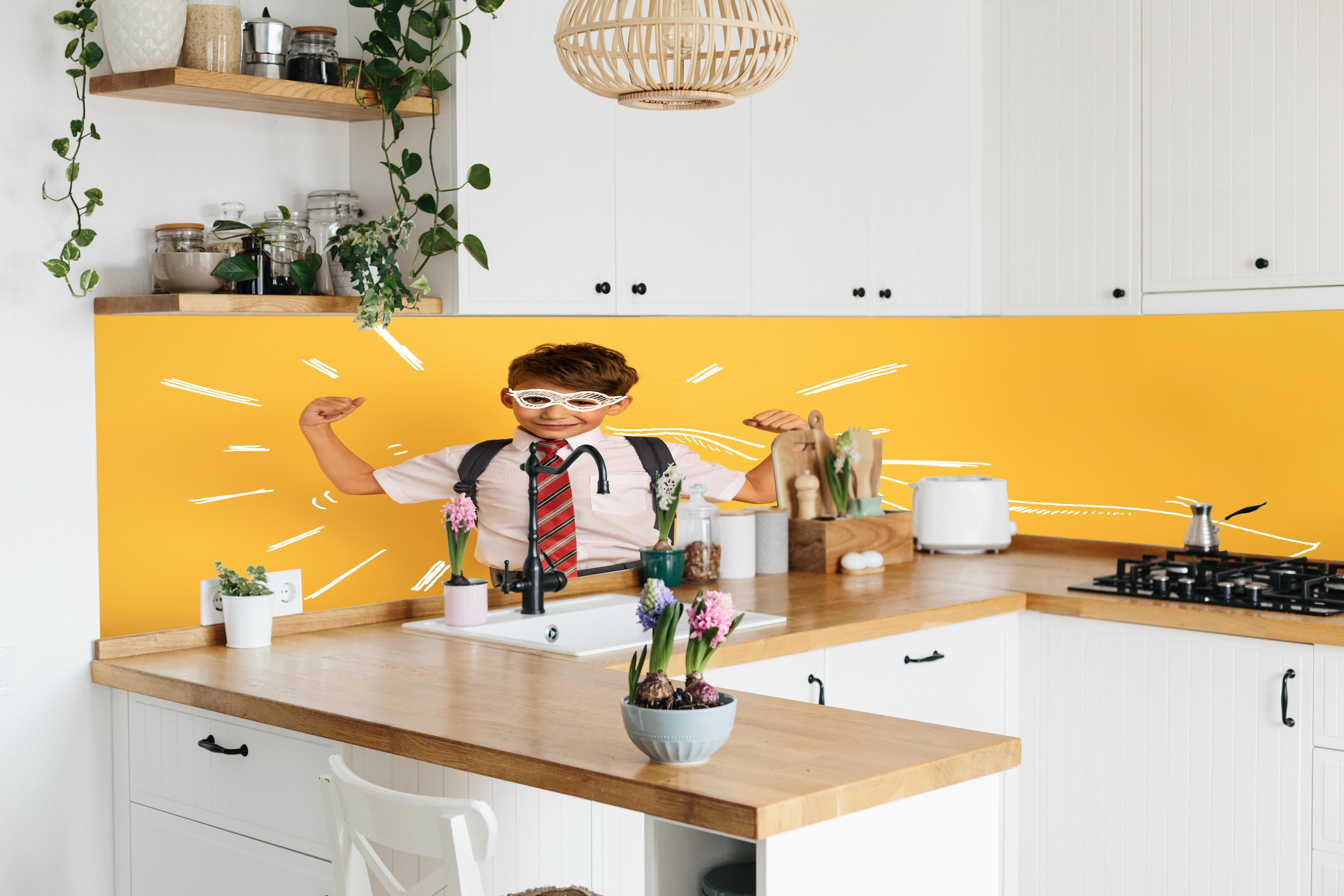 Küche - Junger Schüler hinter weißen Hochglanz-Küchenregalen und schwarzem Wasserhahn