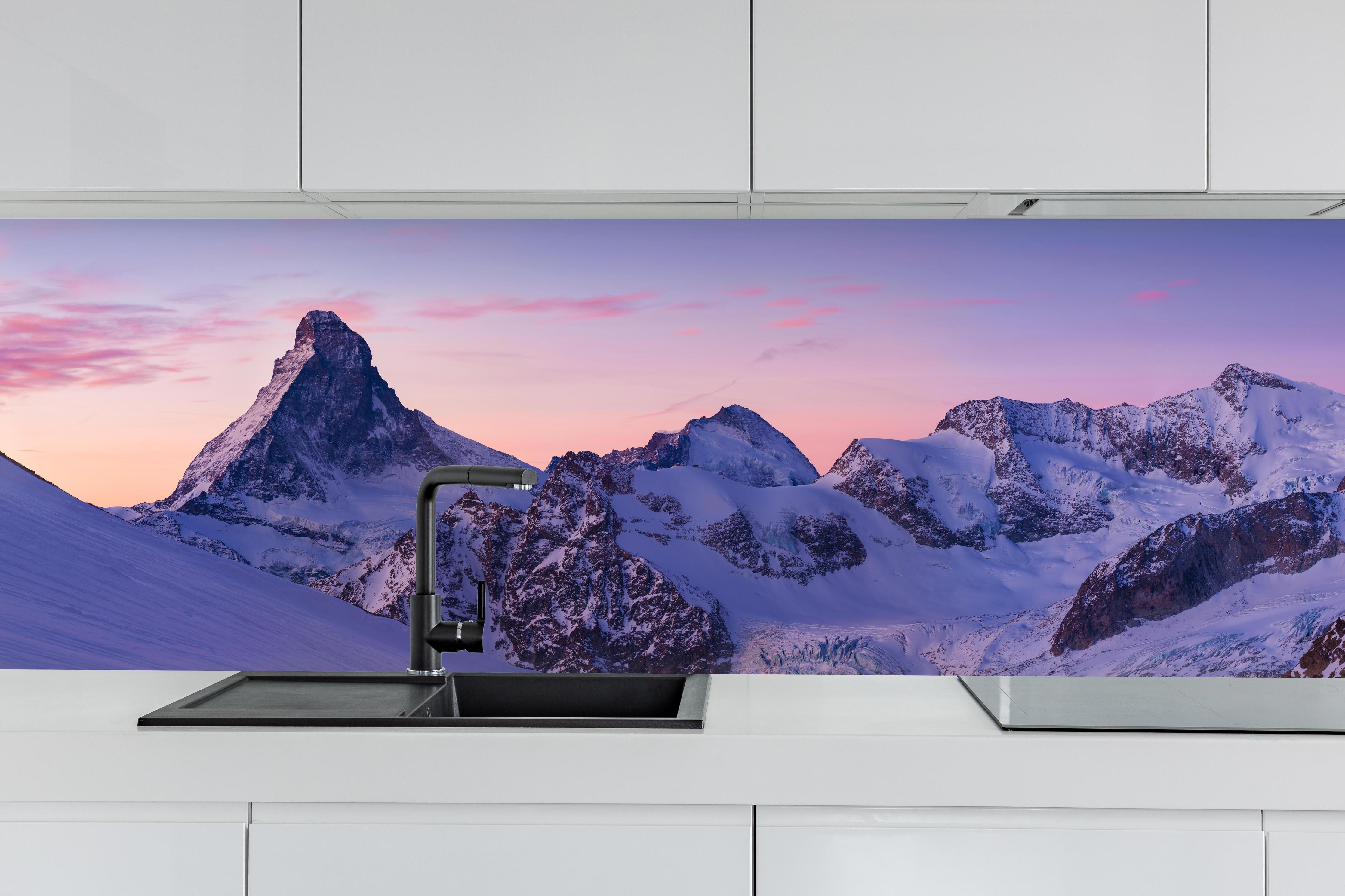 Küche - Alpenpanorama Sonnenuntergang Weiß-Rosa hinter weißen Hochglanz-Küchenregalen und schwarzem Wasserhahn