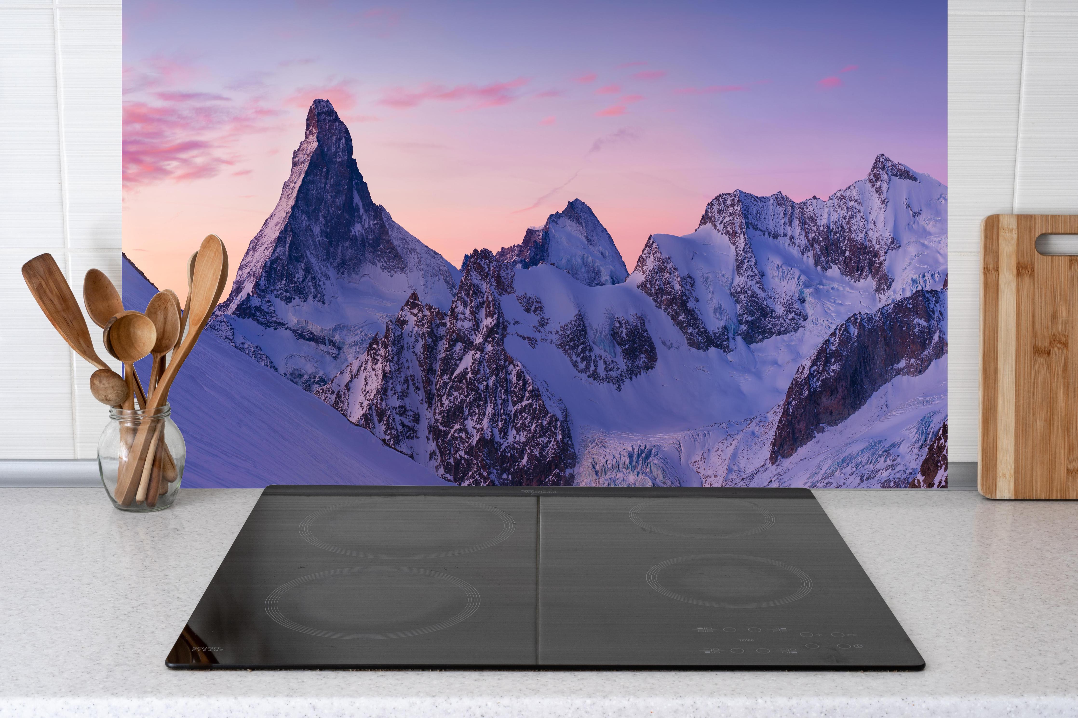 Küche - Alpenpanorama Sonnenuntergang Weiß-Rosa hinter Cerankochfeld und Holz-Kochutensilien