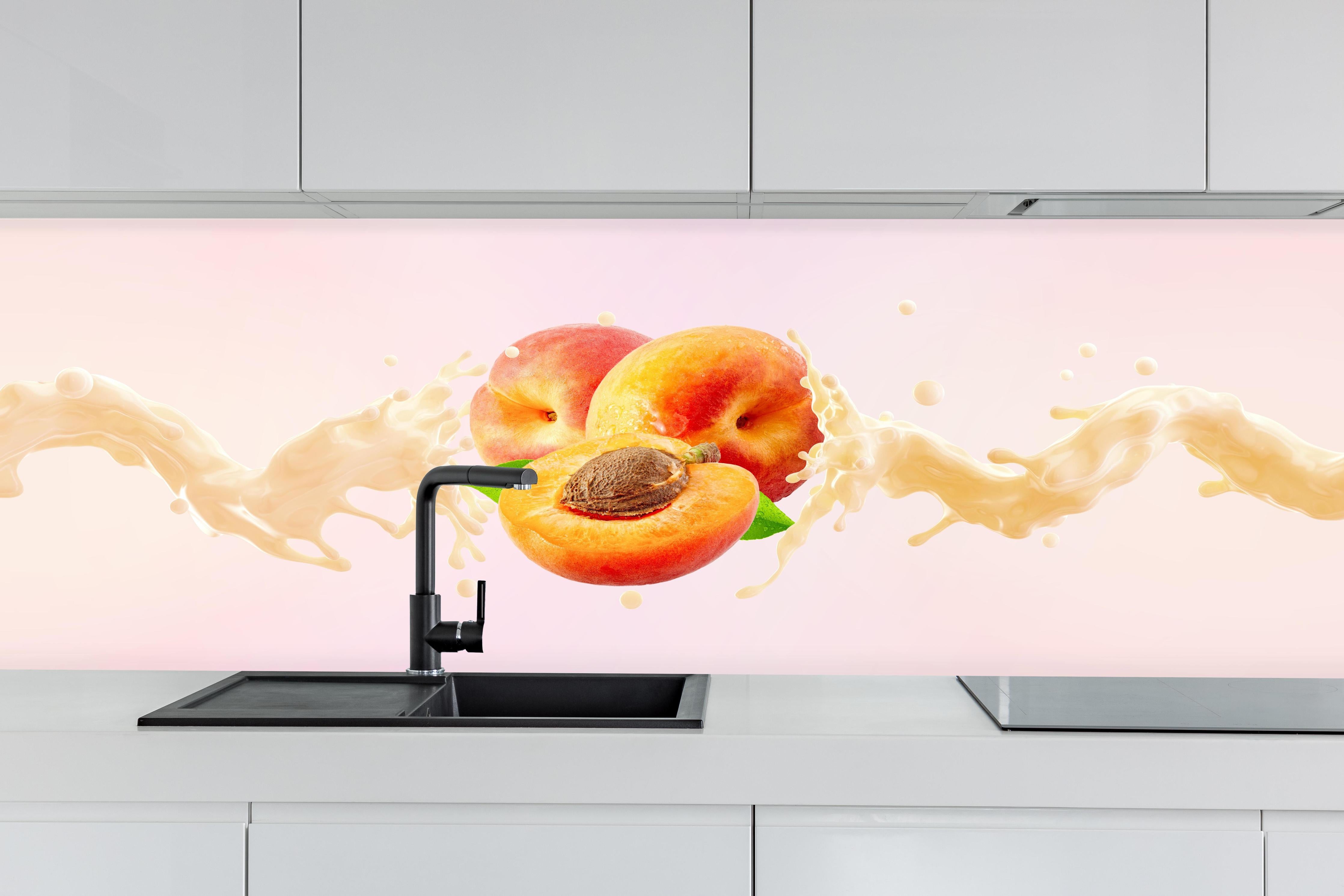 Küche - Aprikosen mit Milch-Splash hinter weißen Hochglanz-Küchenregalen und schwarzem Wasserhahn